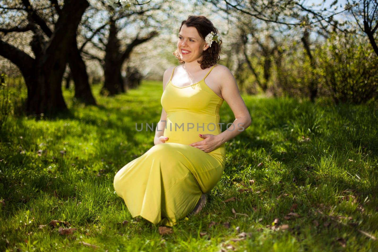 Spring, Young beautiful pregnant woman in the Orchard