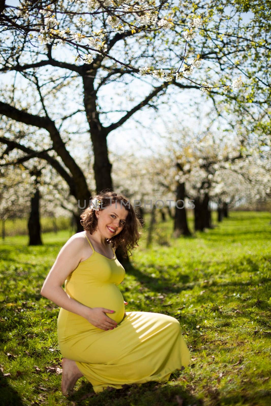 Beautiful pregnant woman relaxing outside in the Orchard