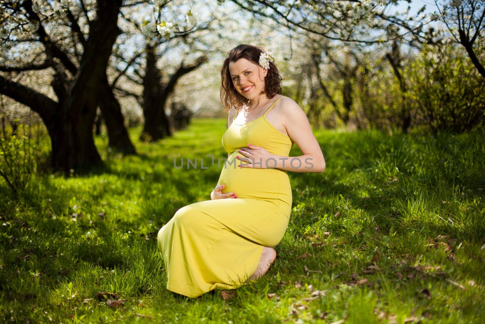 Beautiful pregnant woman relaxing outside in the Orchard