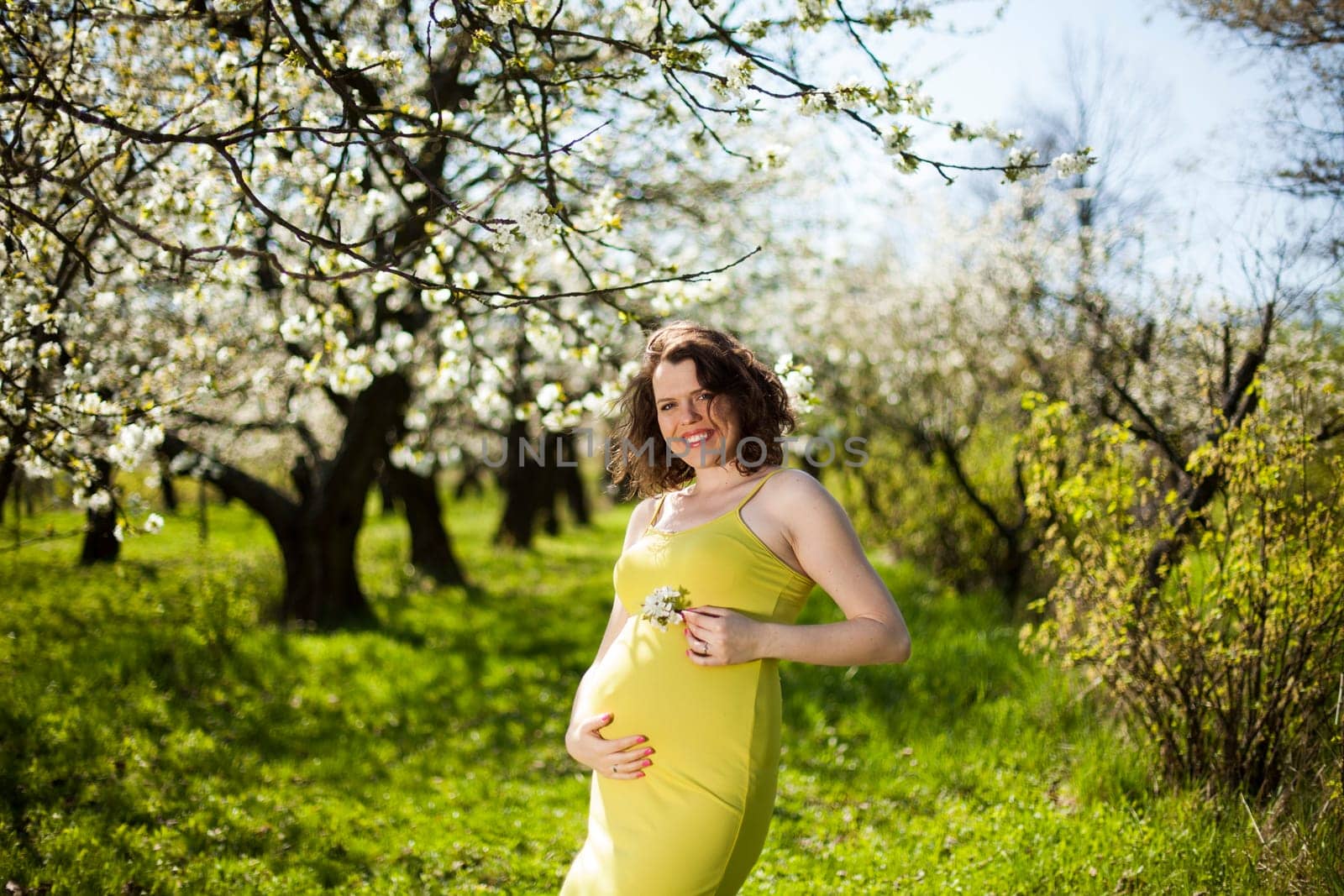 Beautiful pregnant woman relaxing outside in the Orchard