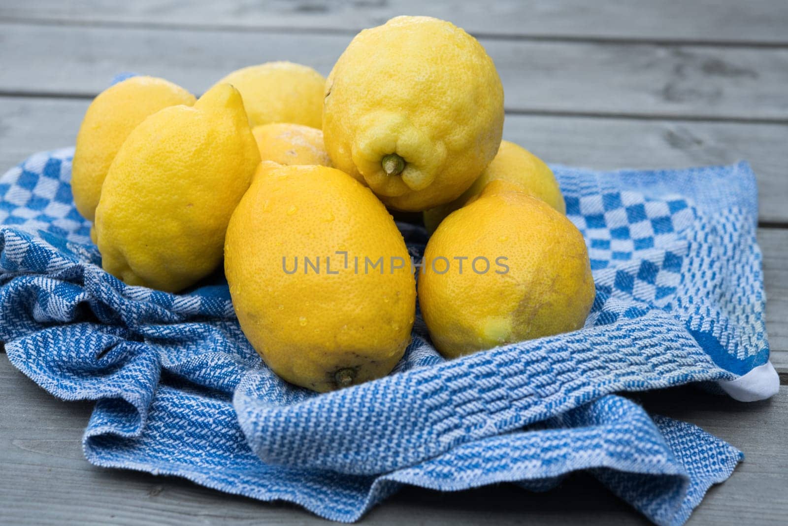 yellow lemons with blue towel on wooden ground