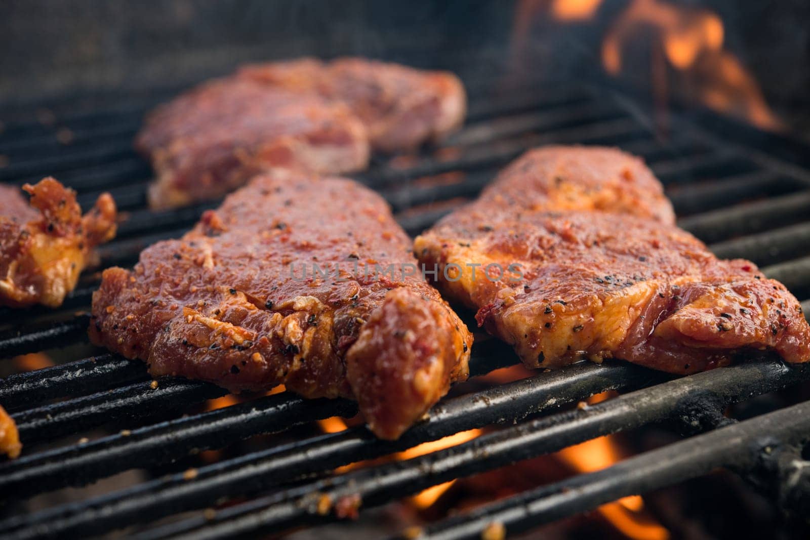 grilled pork with flames on charcoal barbecue