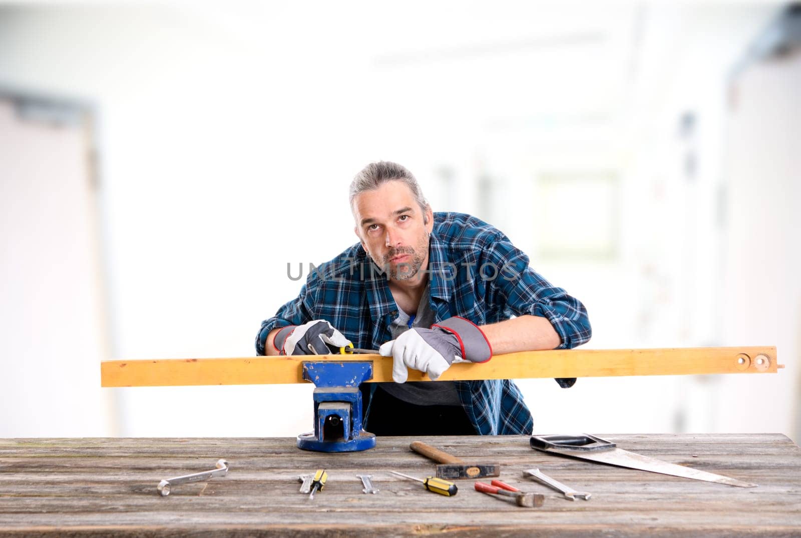 worker in blue plaid  shirt working with wood