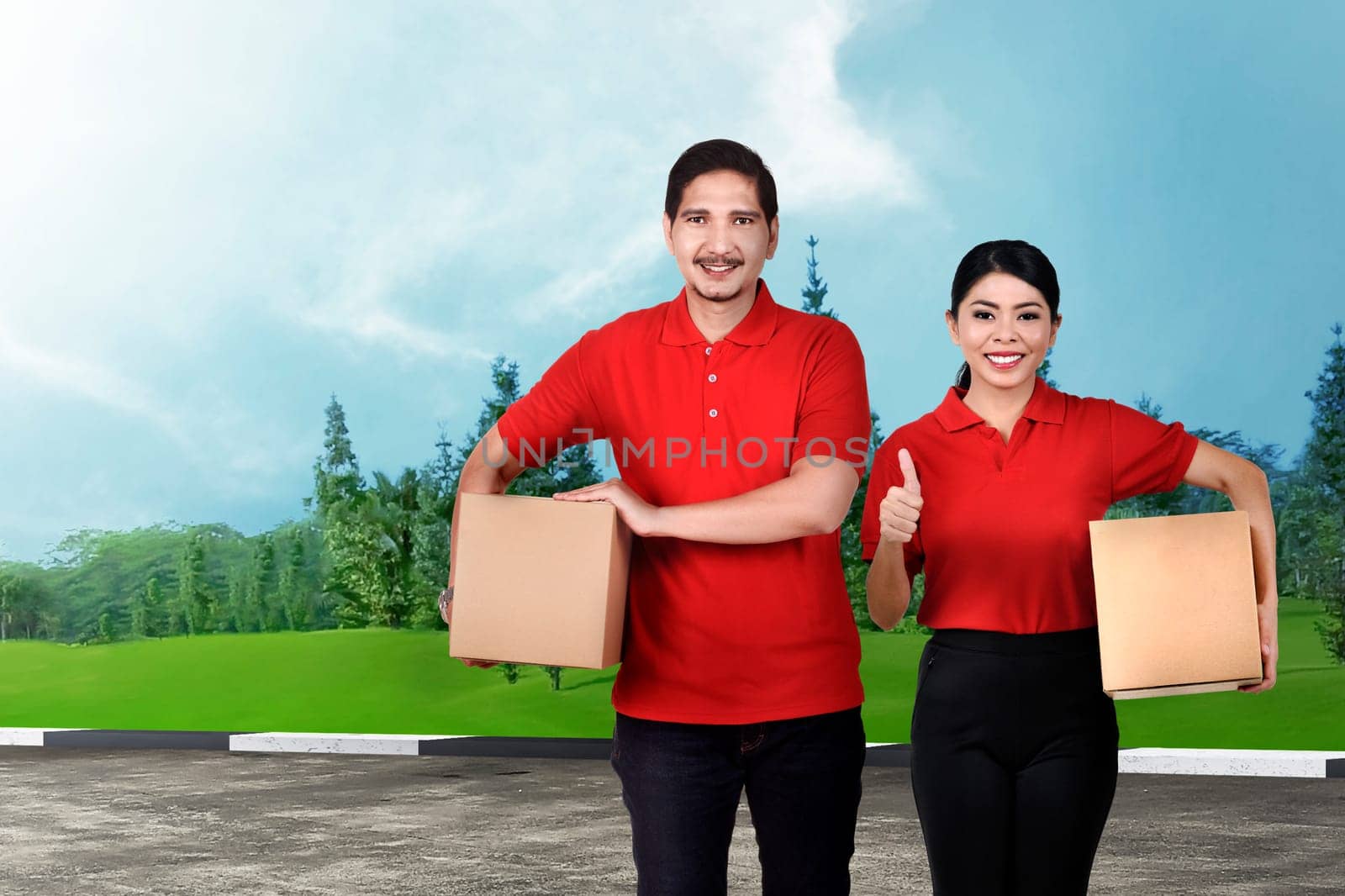 Smiling asian delivery service team with the package on the street