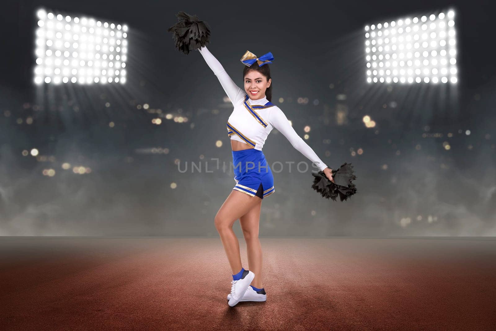 Happy asian cheerleader performing with poms on the stadium