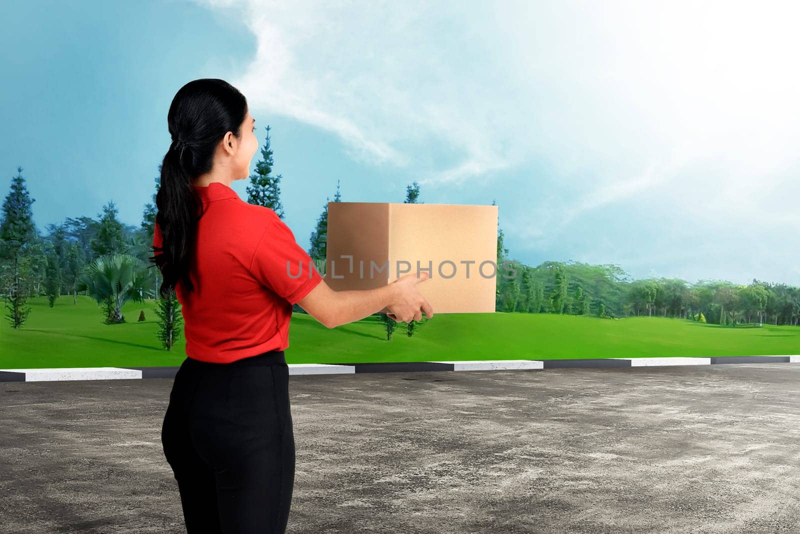 Happy asian delivery woman carrying the package to delivered