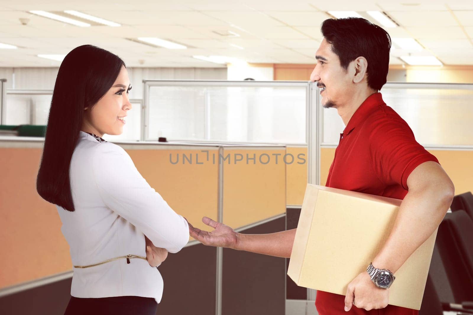 Handsome asian courier man deliver the package to businesswoman at office