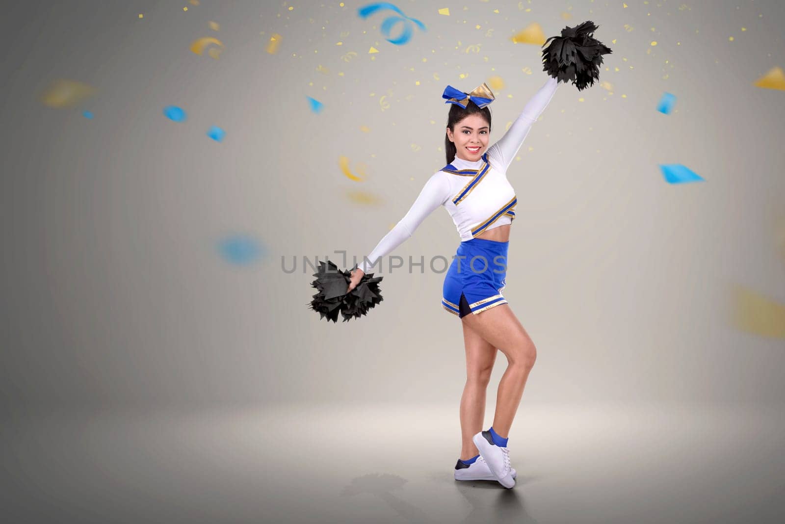 Pretty asian cheerleader in action with confetti background