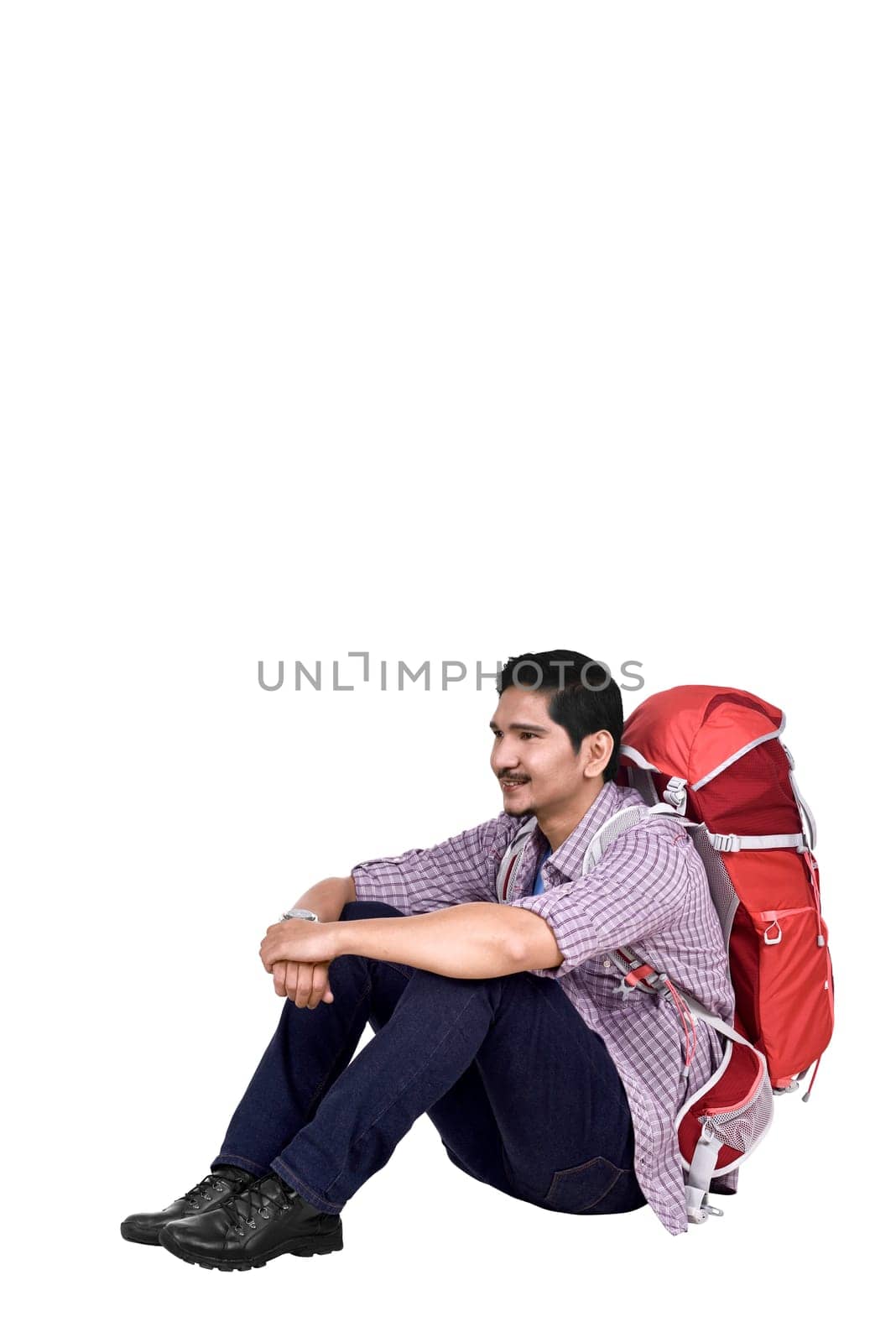 Portrait of asian traveler man with backpack sitting isolated over white background