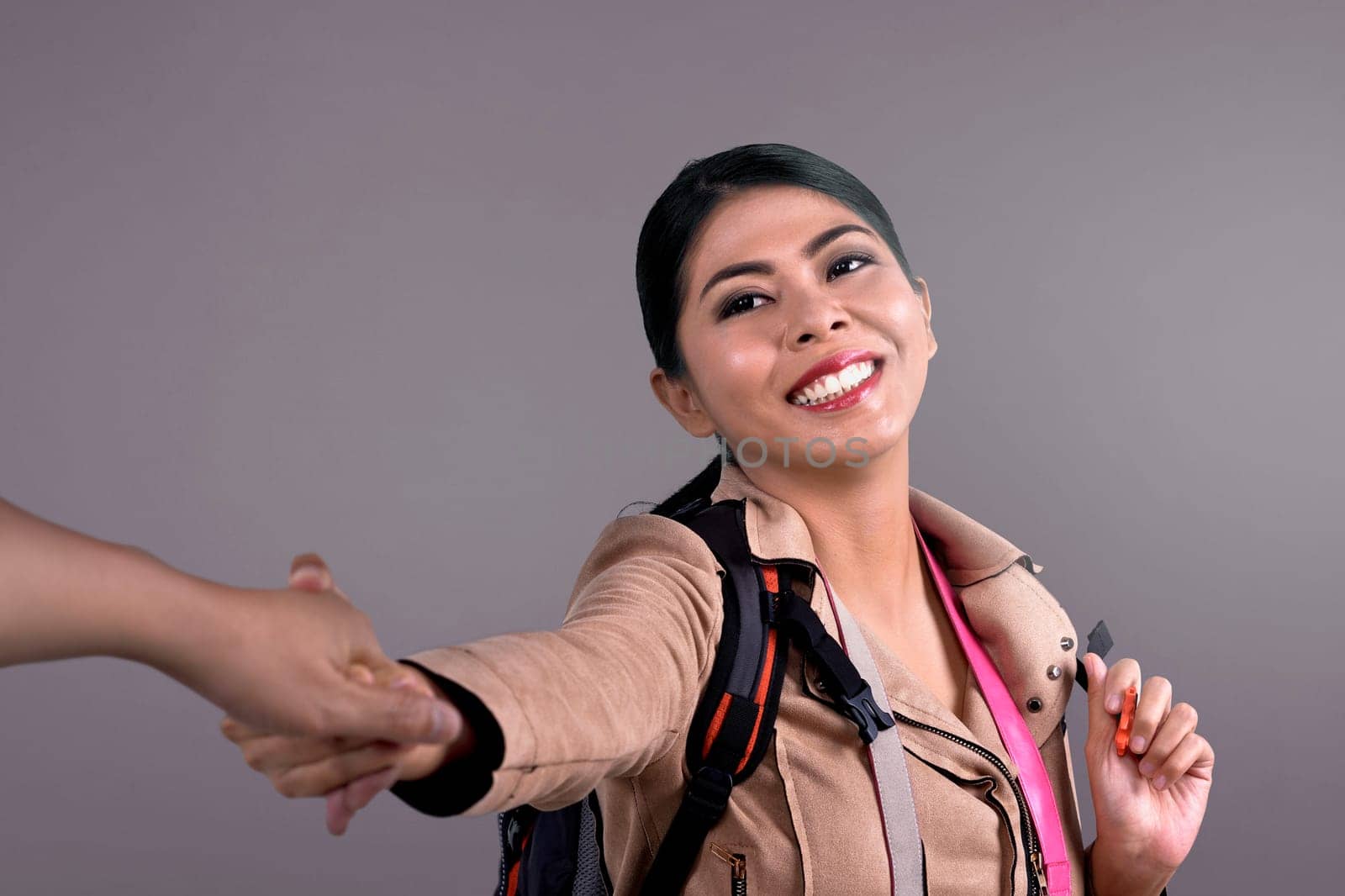 Beautiful asian female tourist following her husband hand with colored background