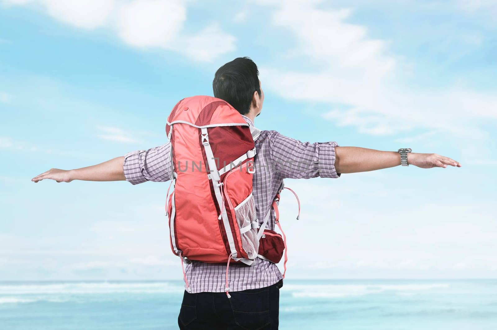 Back view of asian tourist relax and enjoying seascape with blue sky background