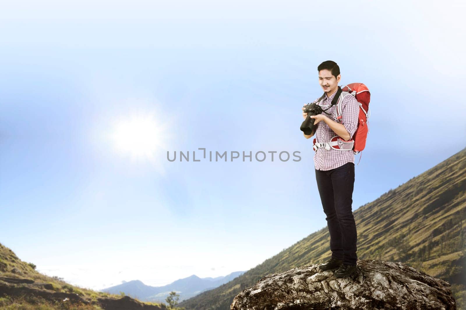 Traveler asian man with camera and backpack climb the mountain