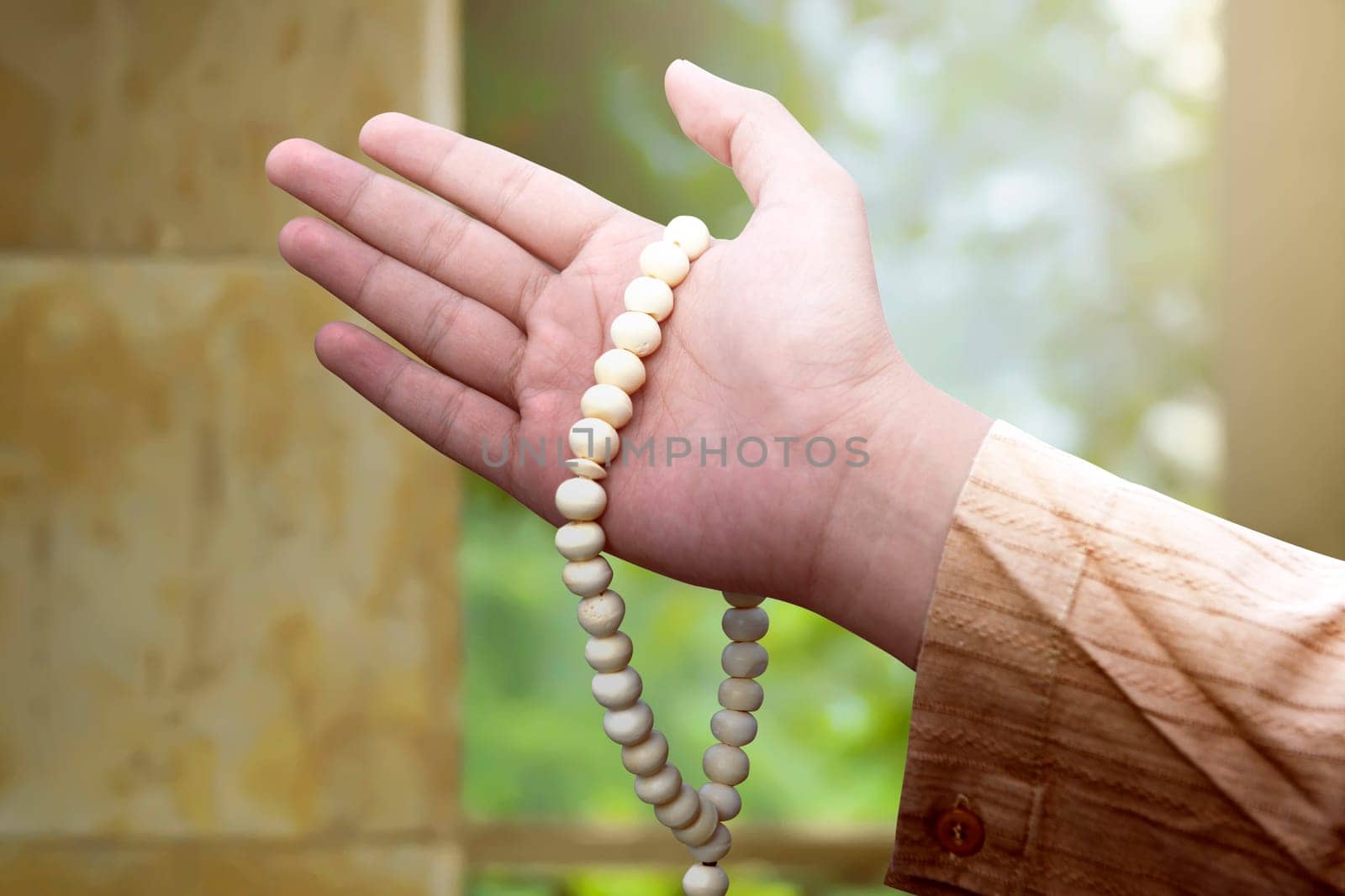 Muslim man holding prayer beads on his hand