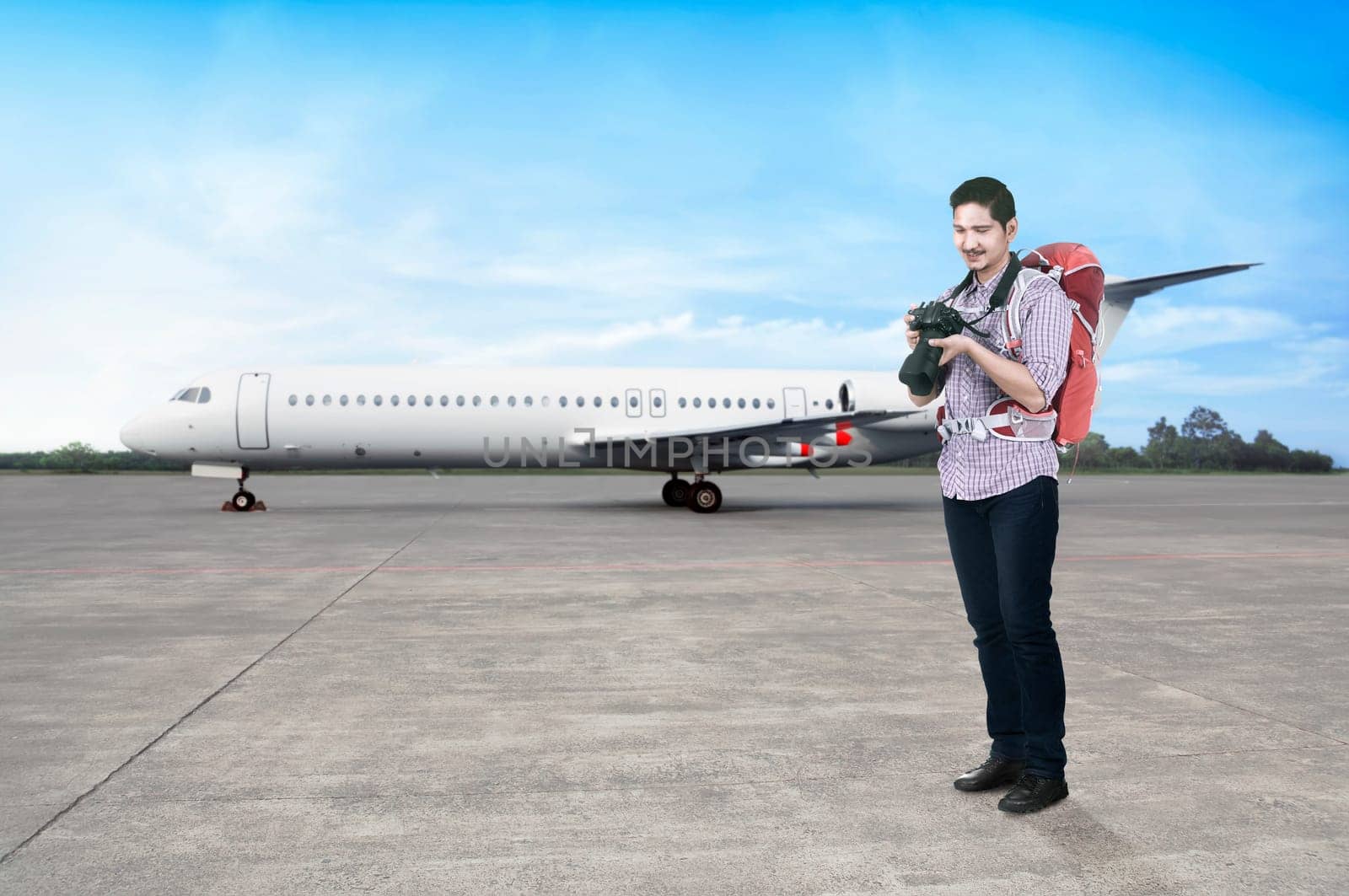 Young asian man with backpack and camera going traveling by airplane