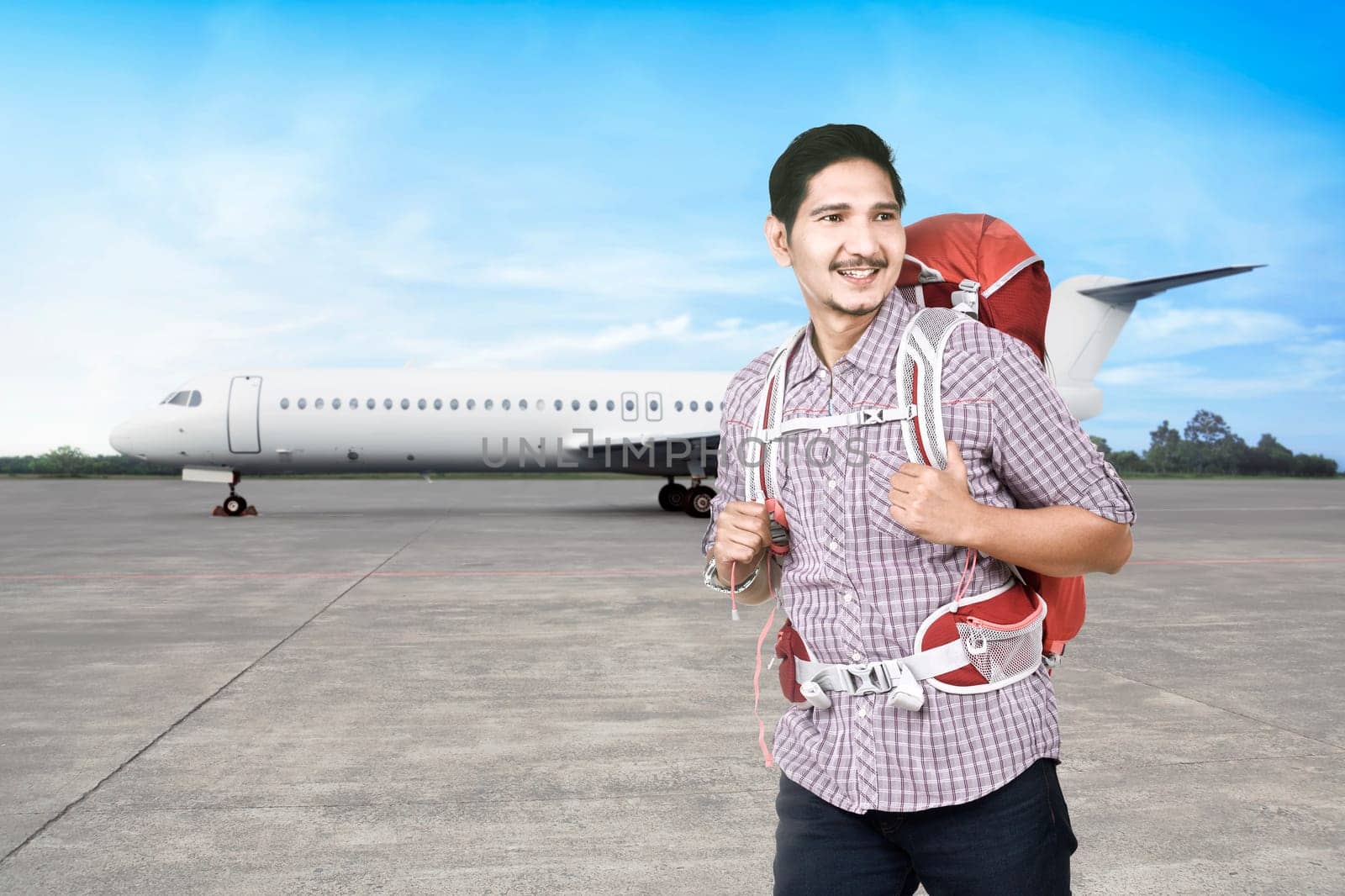 Joyful asian backpacker going traveling by airplane