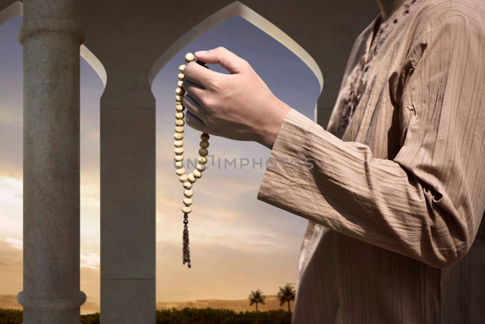 Muslim man praying with prayer beads on the mosque