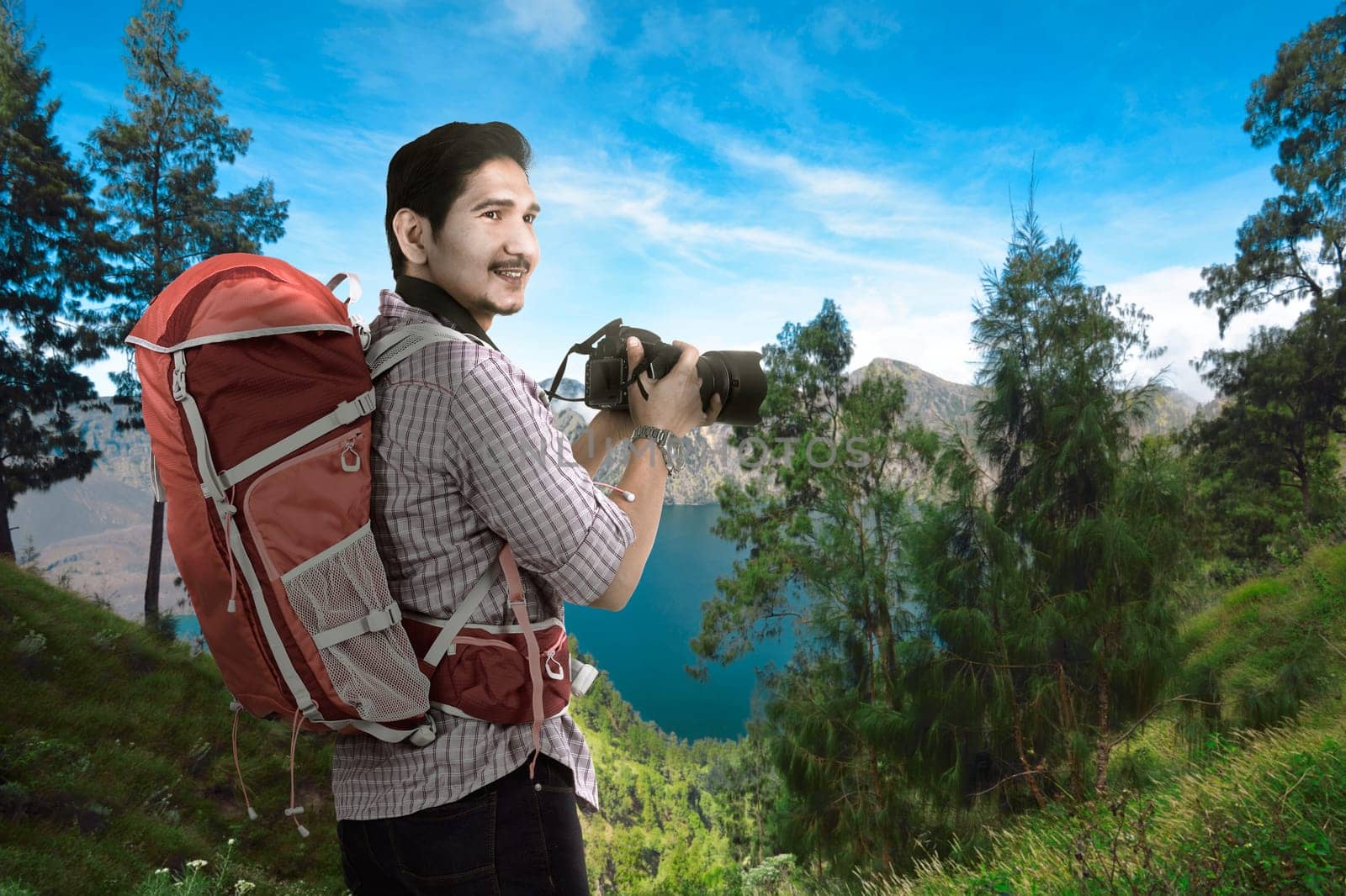 Happy asian traveler man with camera and backpack with scenery background