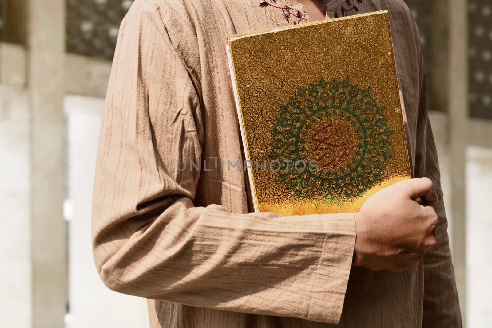 Muslim man holding Quran in the mosque