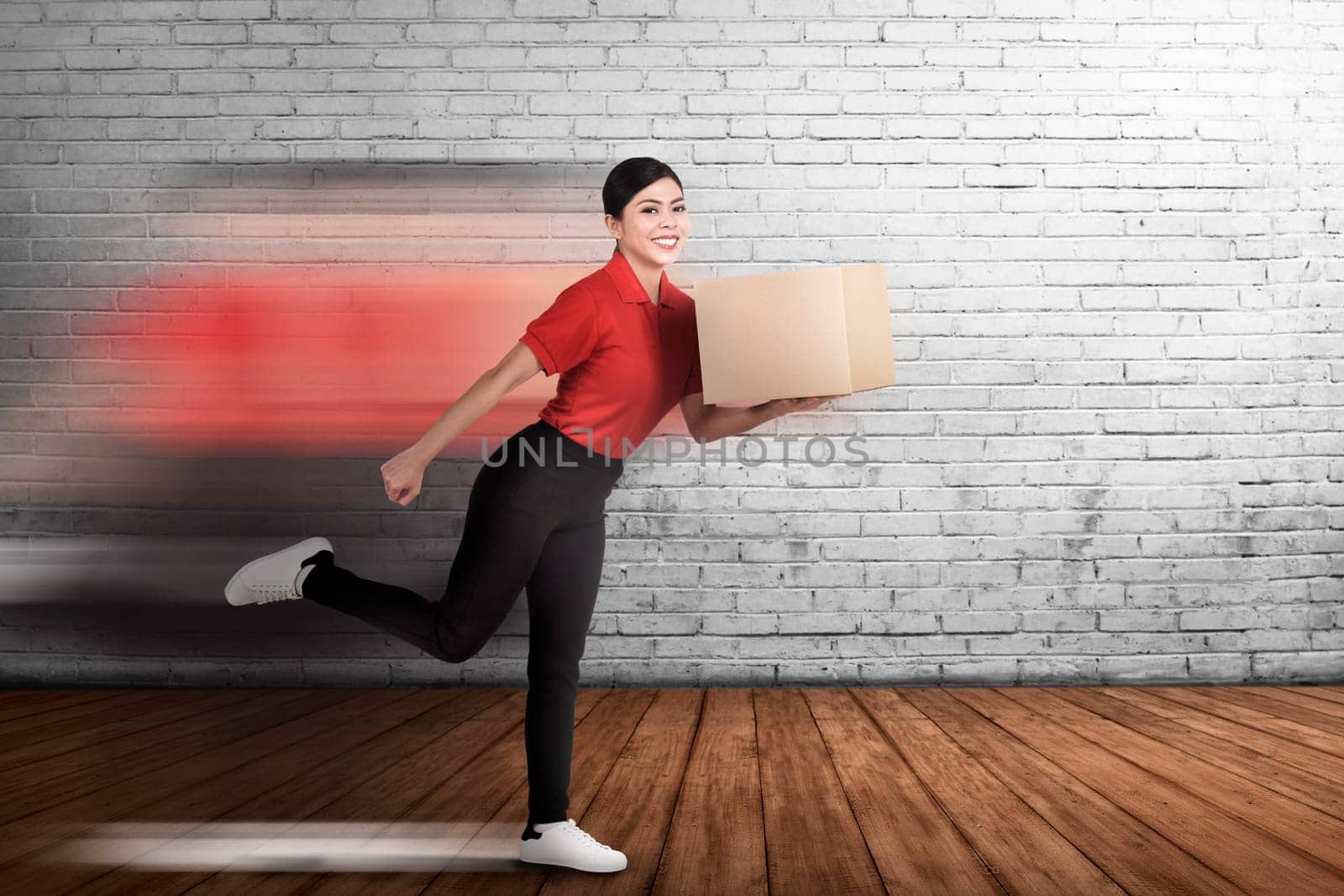 Happy asian courier woman delivering the package with wall background