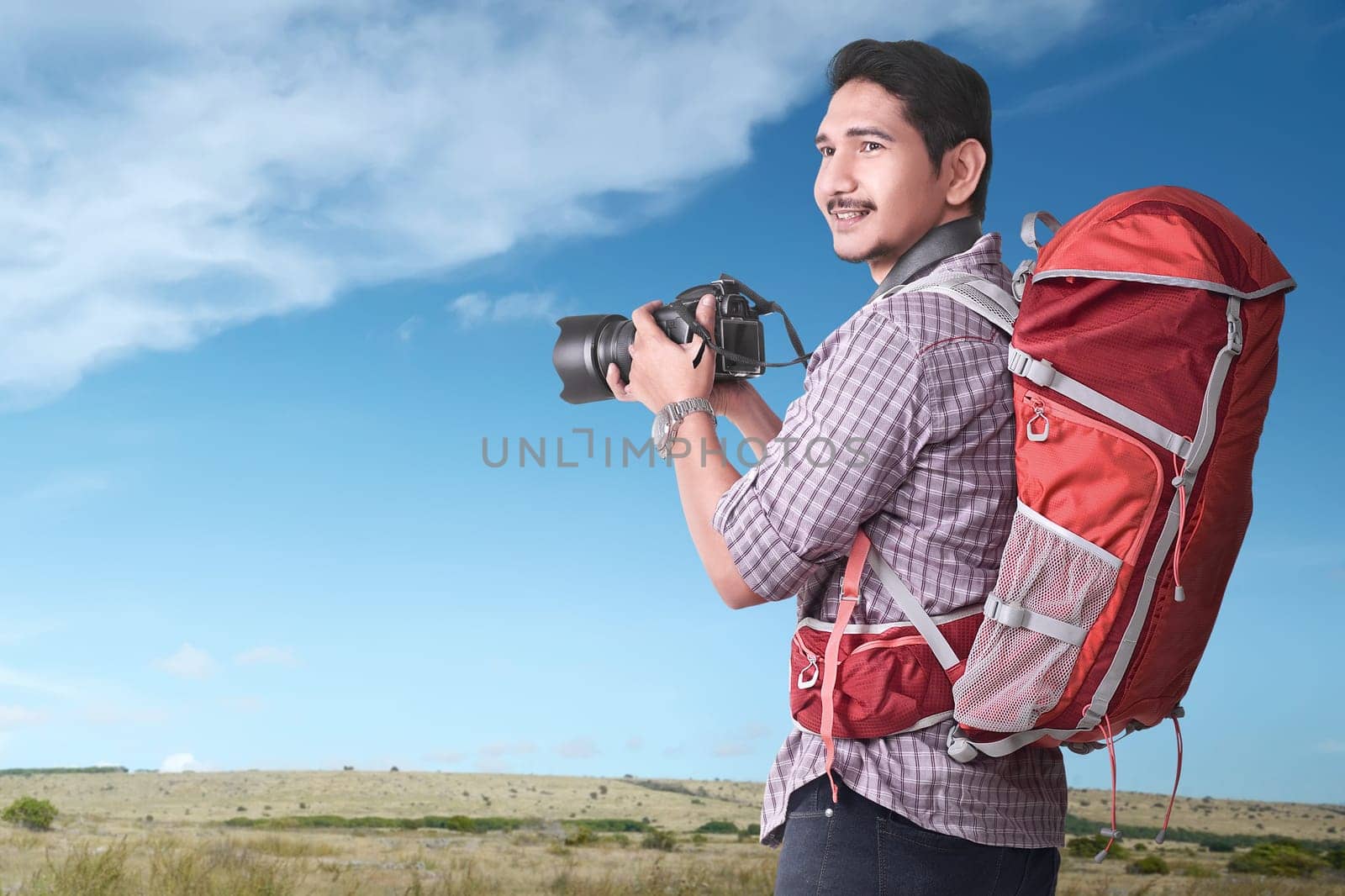 Smiling asian tourist with backpack and camera at outdoor