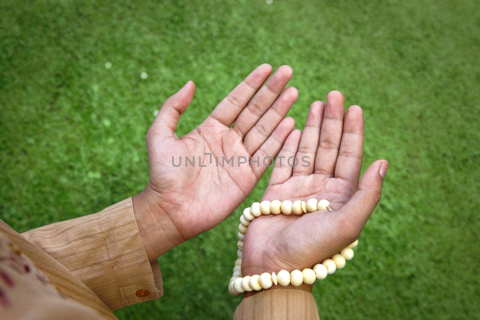 Muslim man praying with prayer beads at outdoor