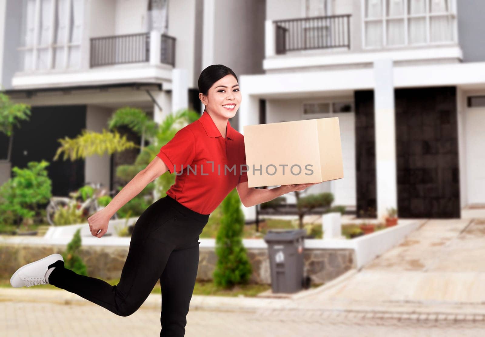 Young asian delivery woman delivering package to destination home