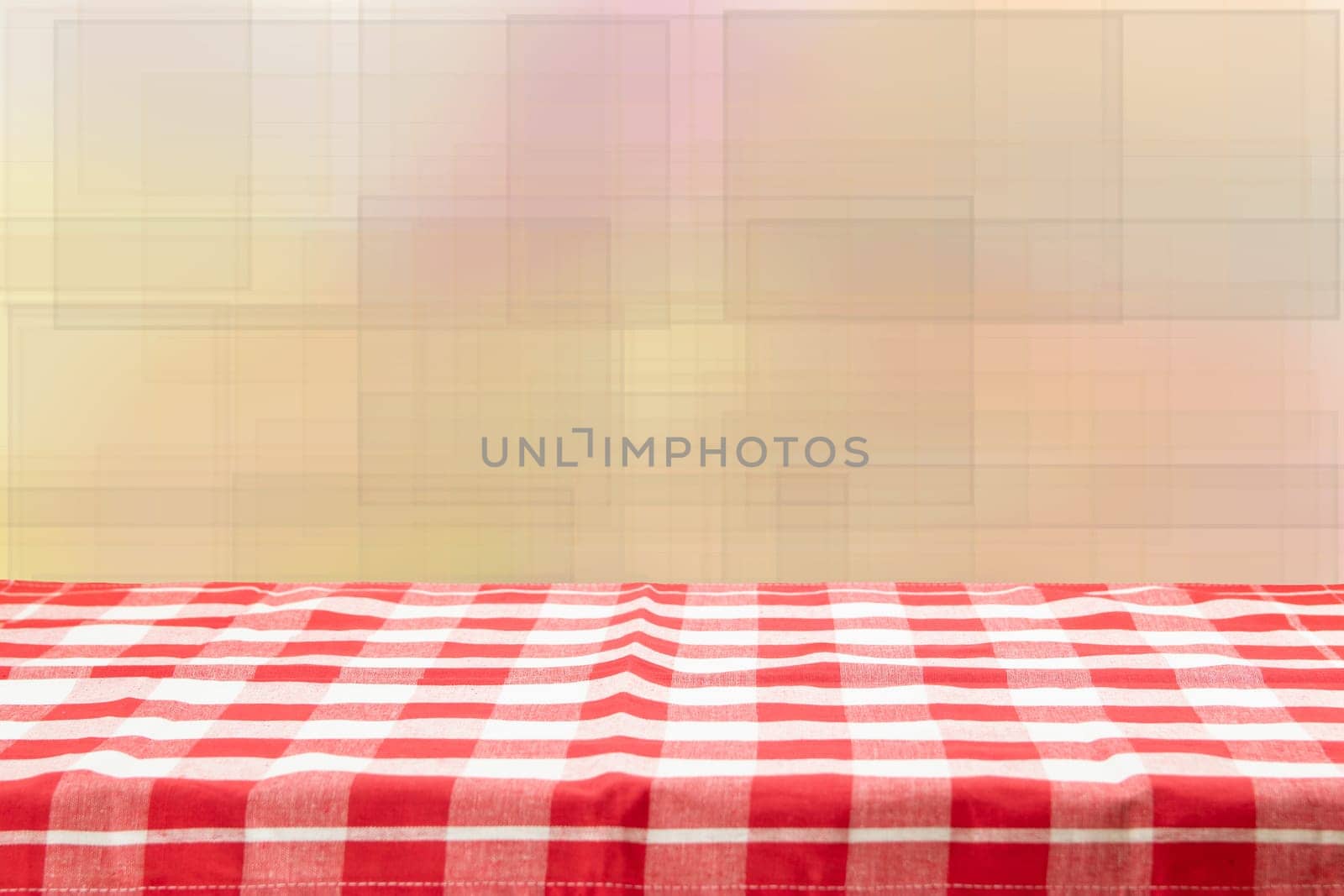 Empty table with red checkered tablecloth and bright bokeh background. For your food and product display montage.