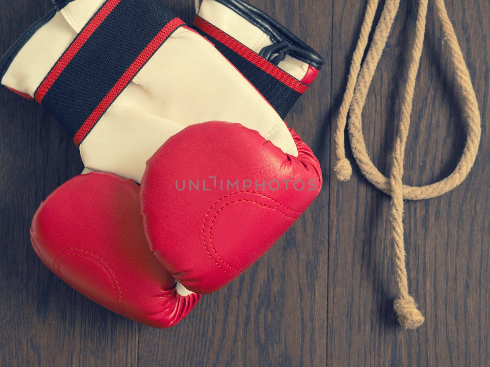 Red boxing gloves on a rustic wooden wall, sports or assertiveness concept