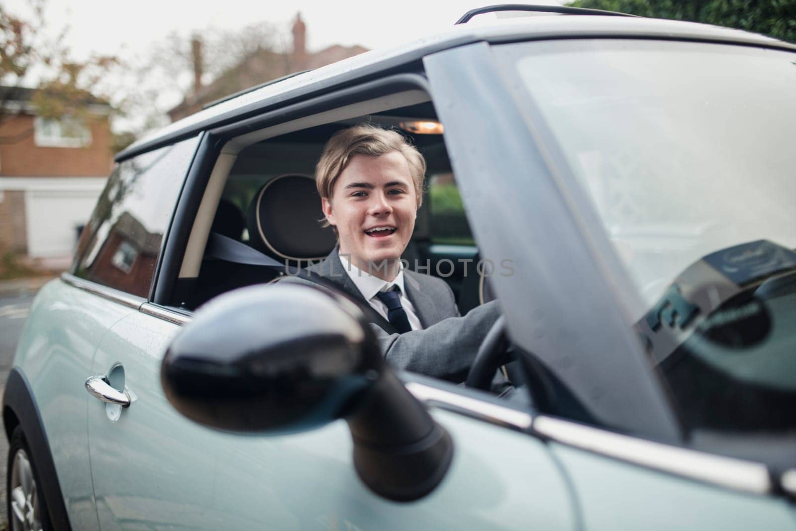 Front view of a young businessman looking at the camera while in a car. Morning commute to work.