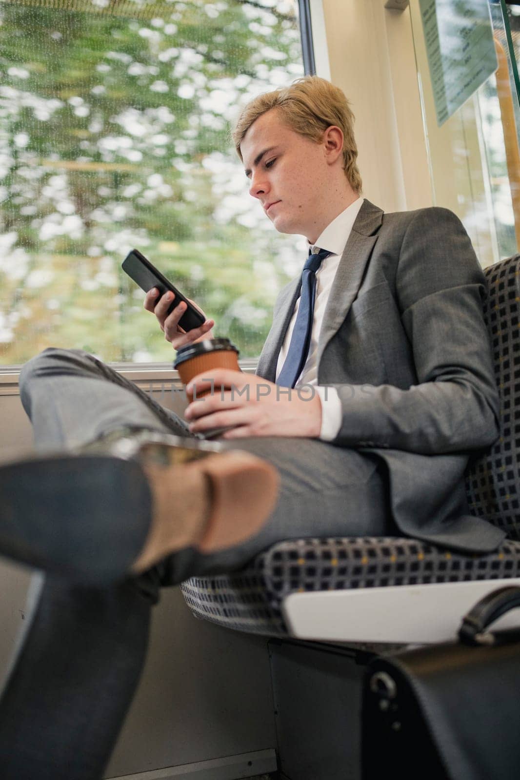 Young Businessman on his morning commute to work. Checking his smart phone for notifications.