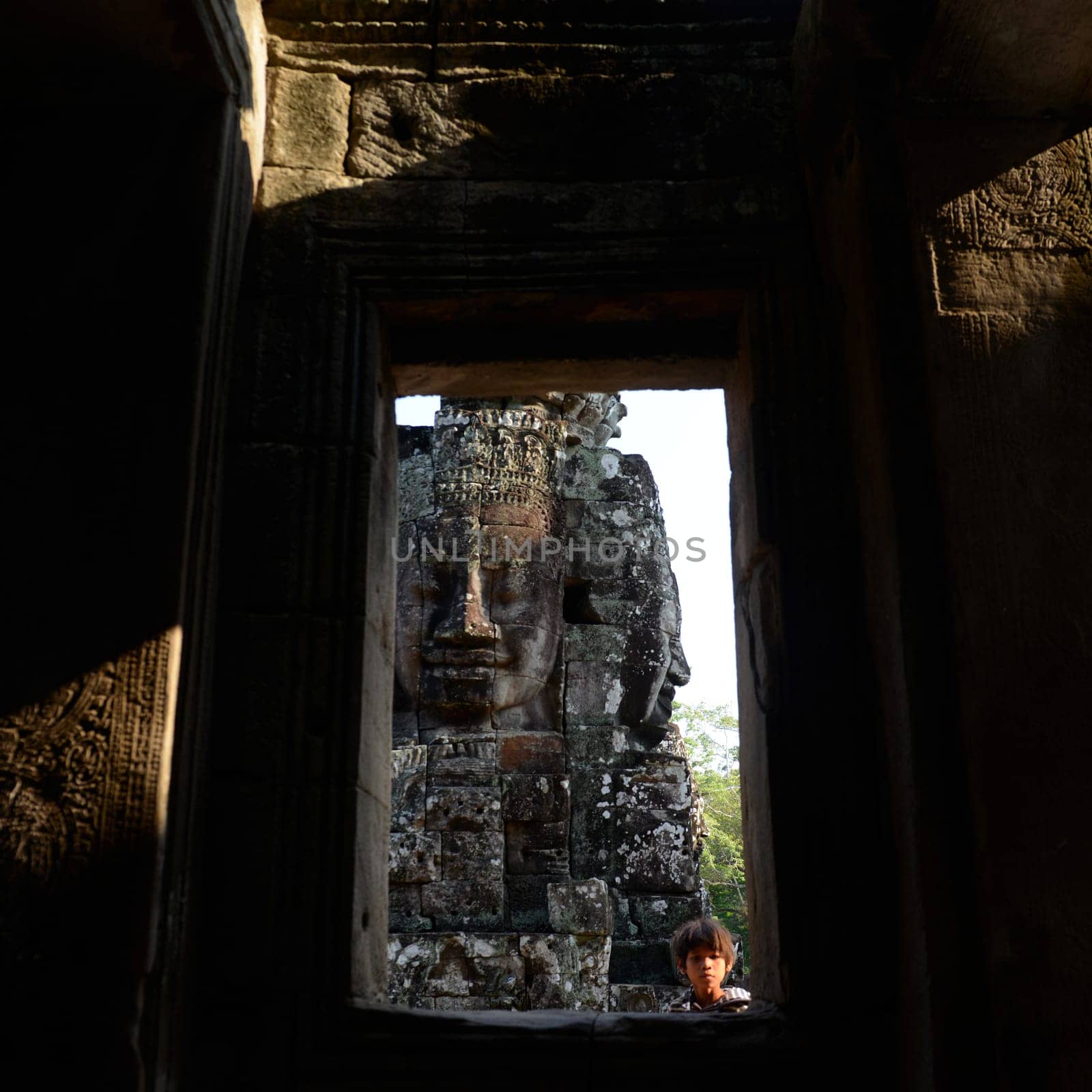 Stone face at the Bayon Temple the Tempel Ruins of Angkor Thom in the Temple City of Angkor near the City of Siem Reap in the west of Cambodia.  Cambodia, Siem Reap, April 2014