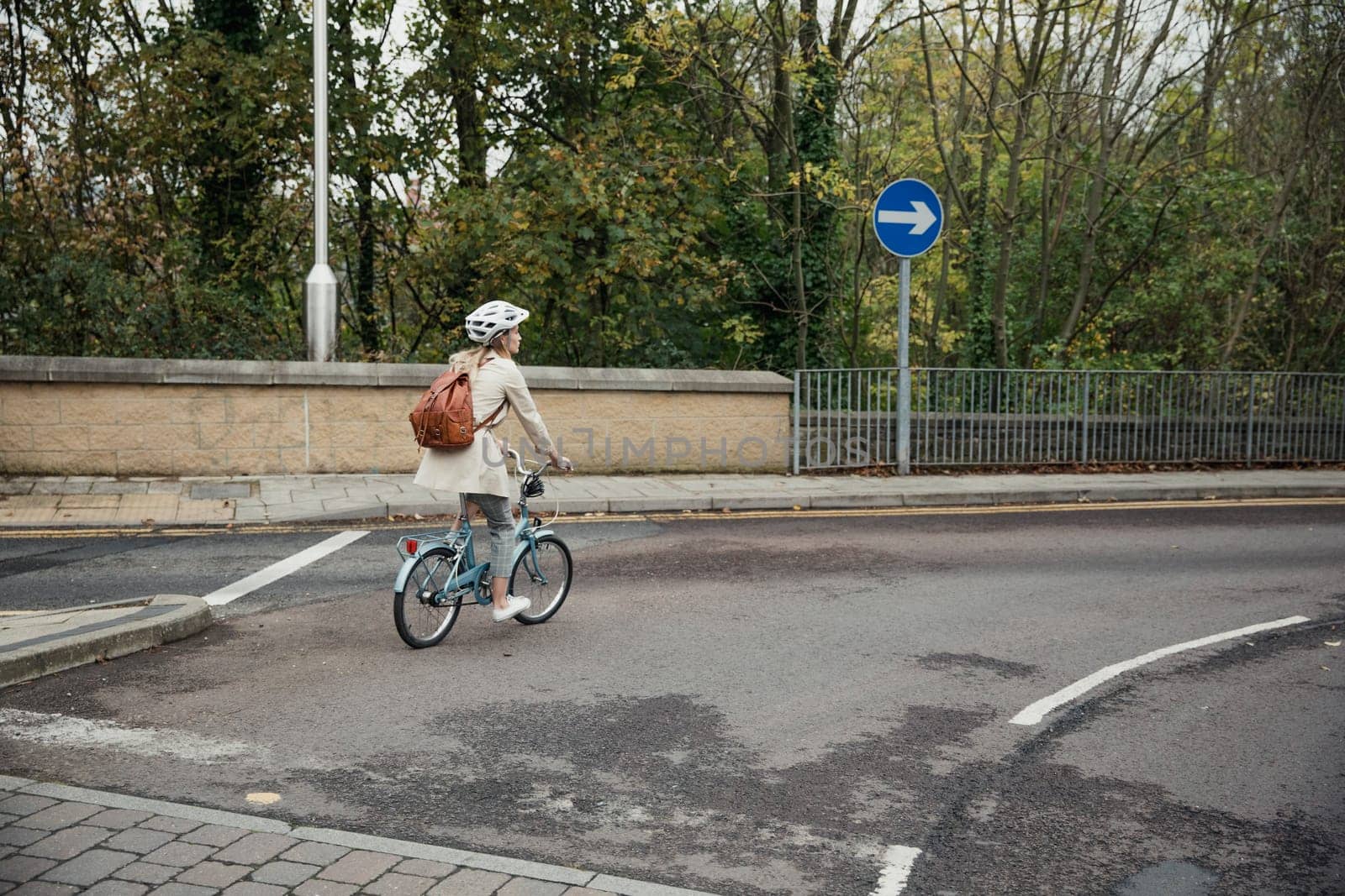 Wide angle, rear view of an unrecognisable person using a bike as her mode of transport to get to work.