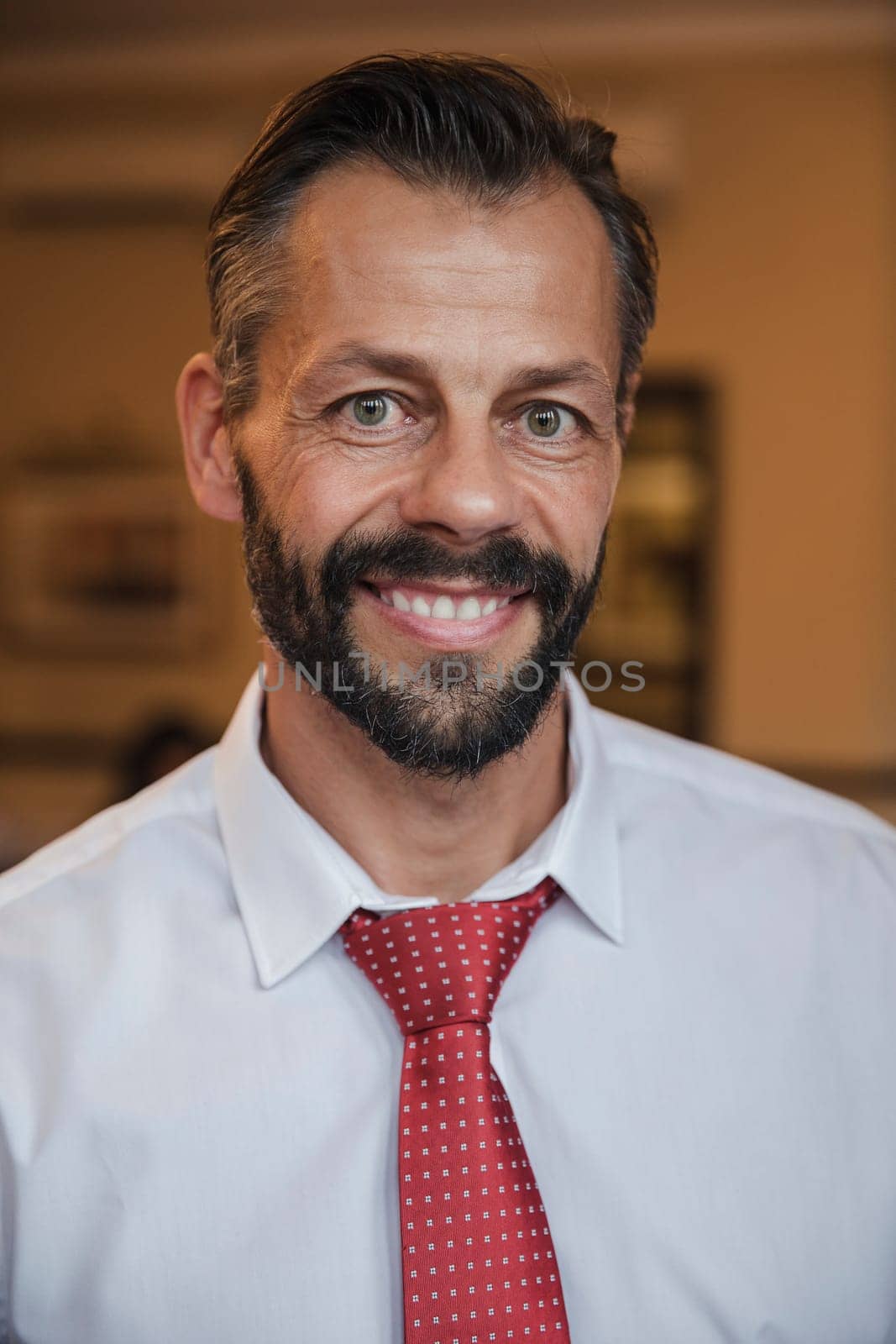 Front view of a mature businessman giving a smile for the camera.