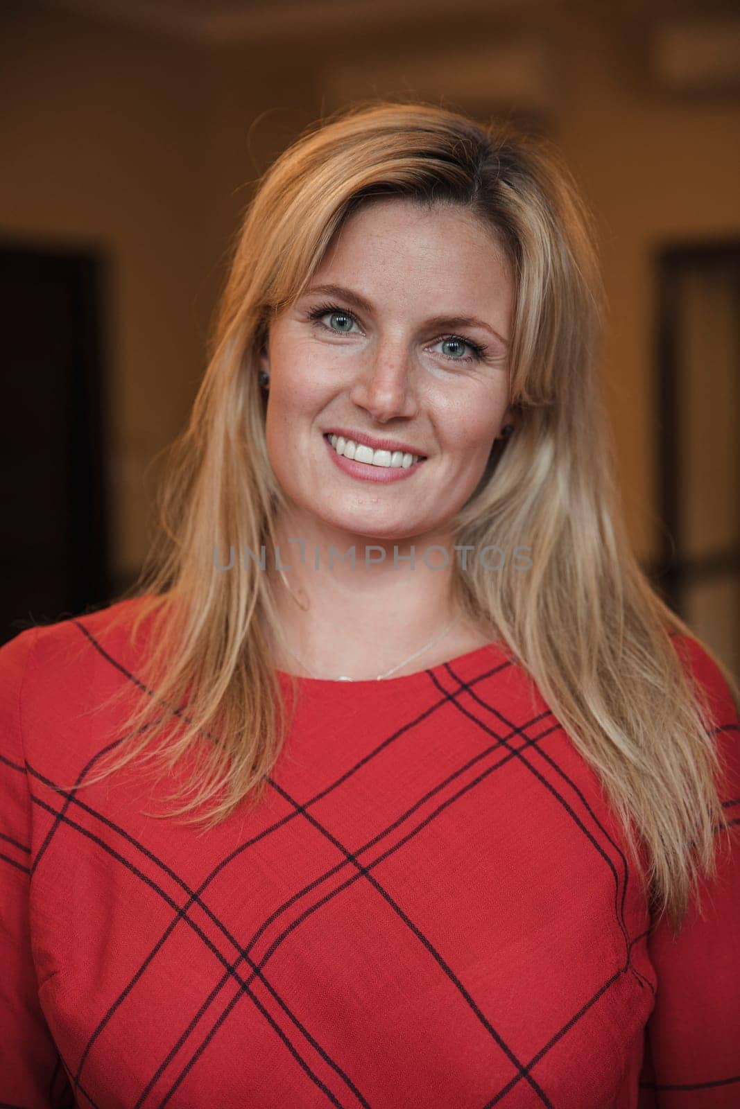 Close-up, front view portrait of a mid-adult businesswoman smiling for the camera.