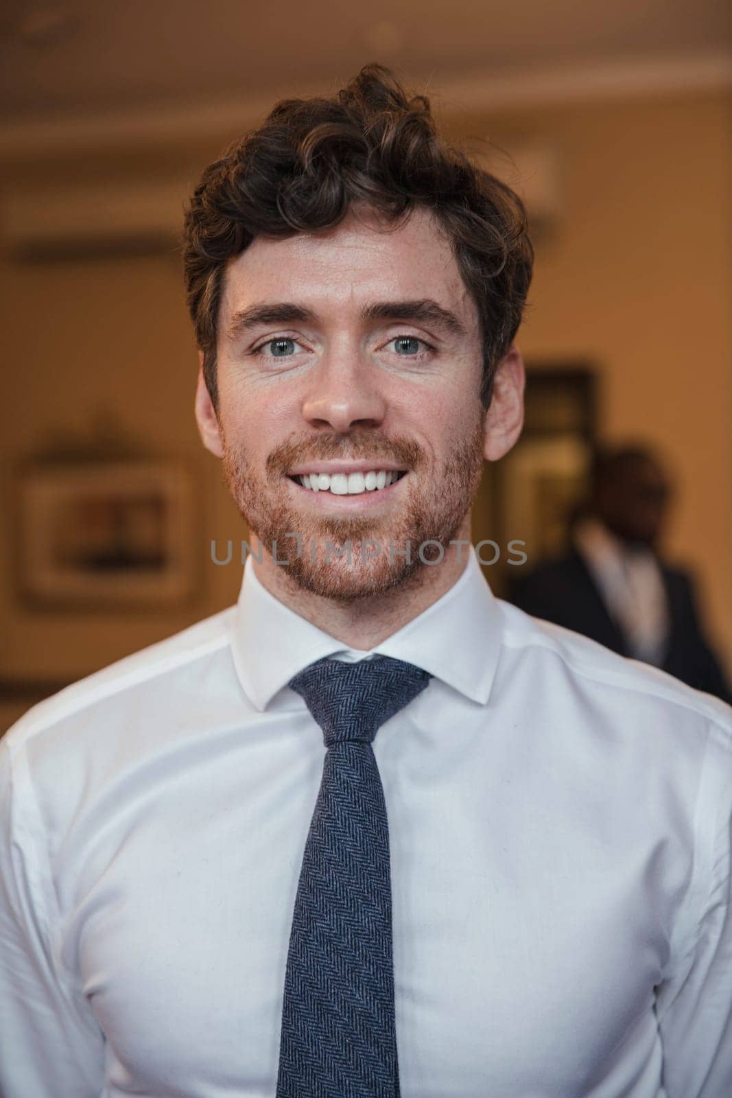 Front view of a young businessman giving a smile for the camera.