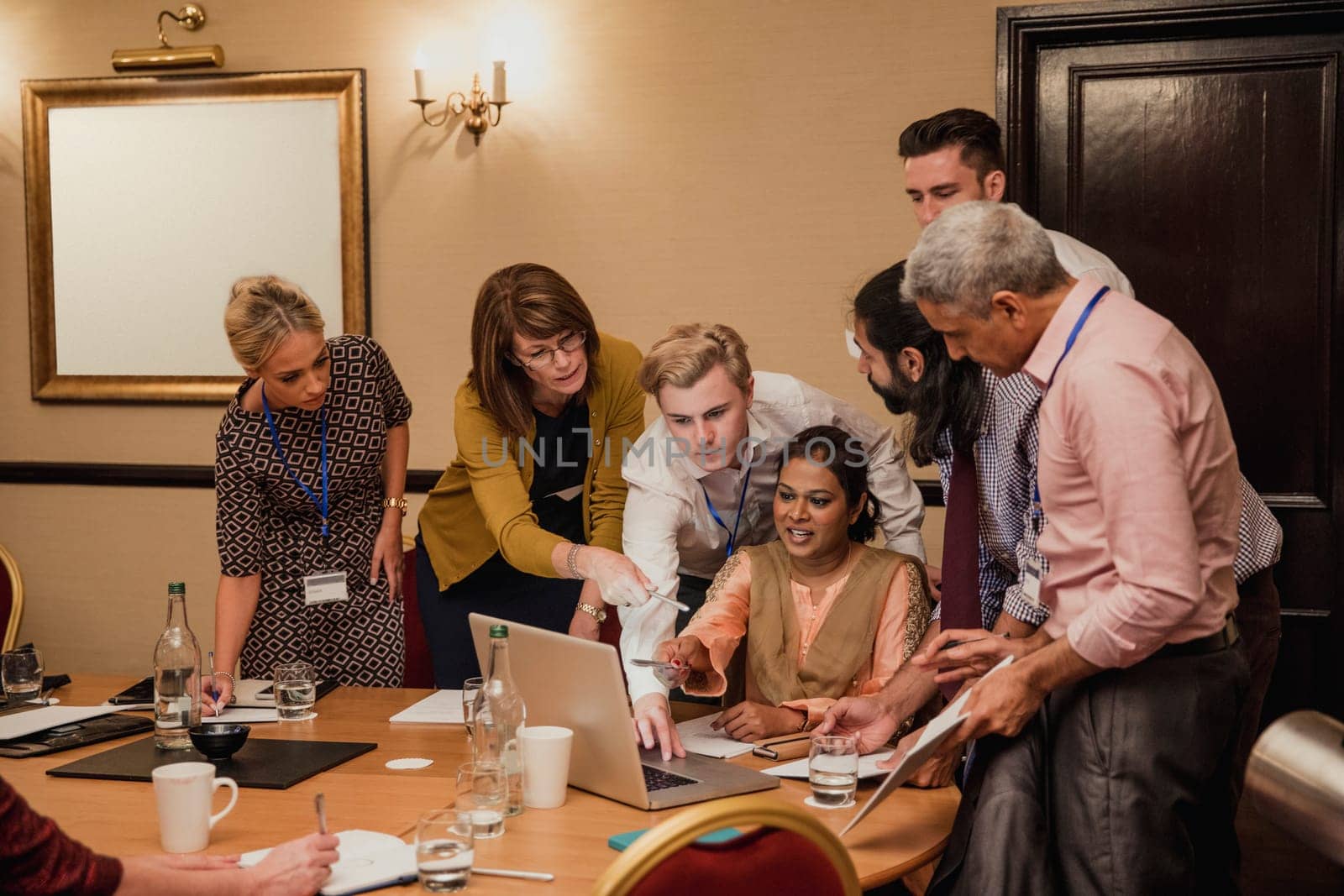 Medium sized group of business people working late and together to get work finished.