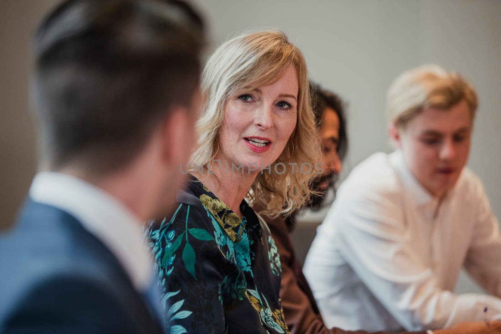 Over the shoulder, point of view shot of a business woman looking towards a business man and talking.