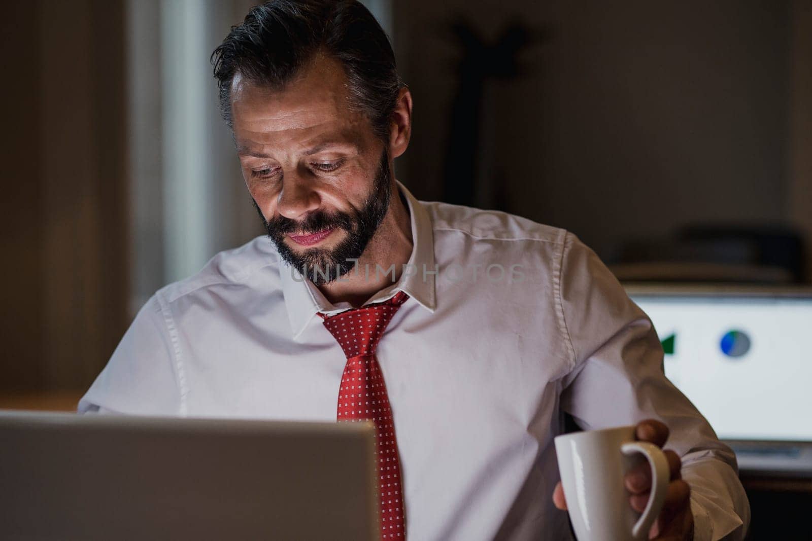 Front view of a businessman working late in the office to get his work finished before the deadline.