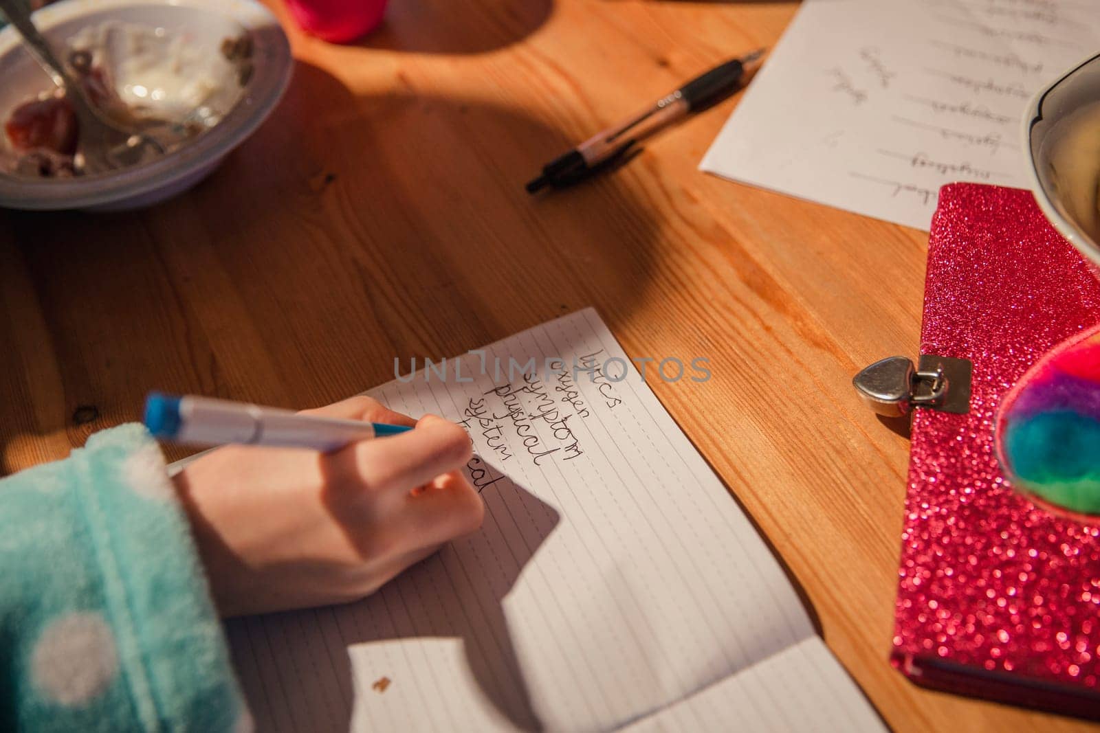 Close-up of a little girls hand writing her spellings out. Doing homework before school.