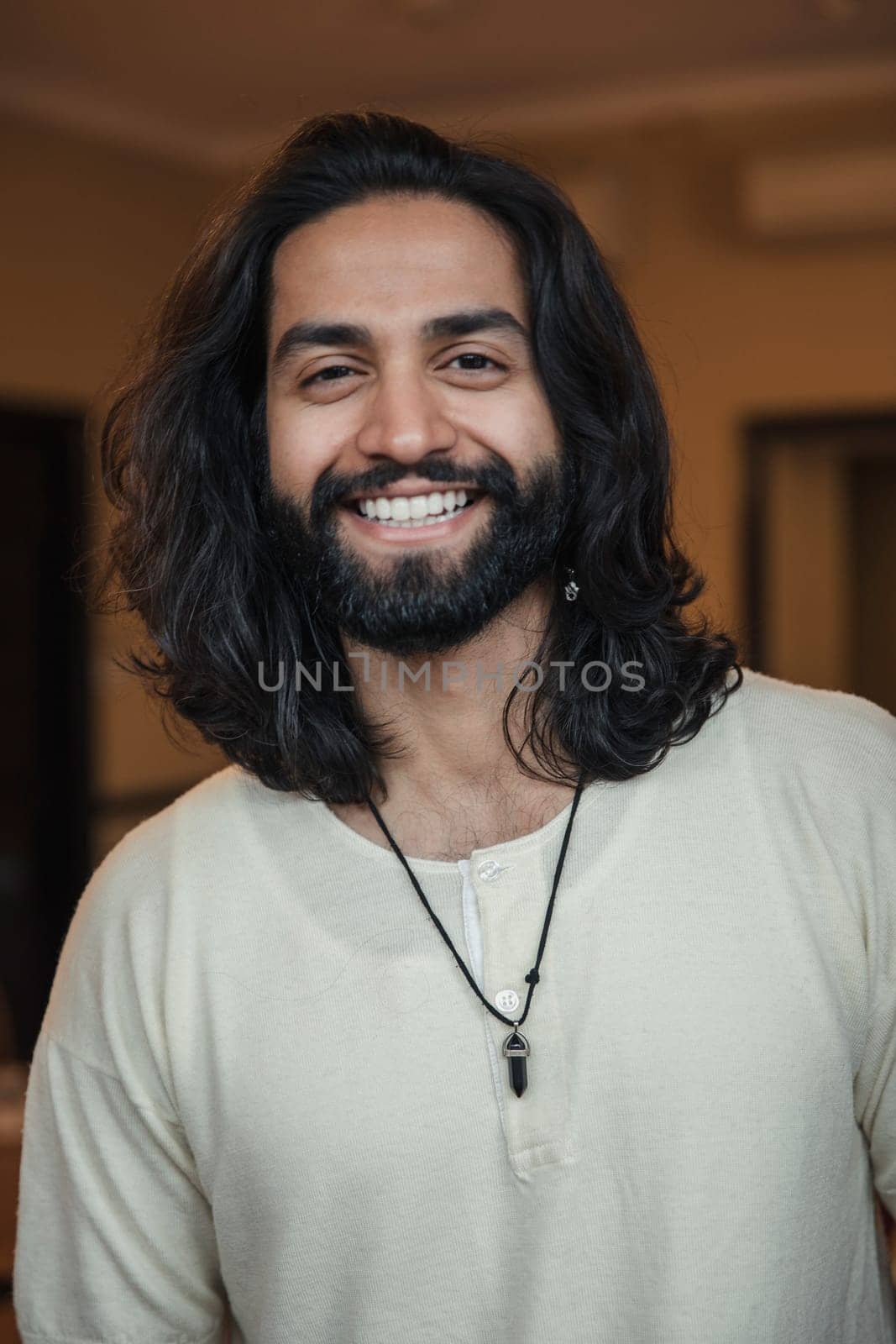 Close-up, front view headshot of a young male adult smiling at the camera.