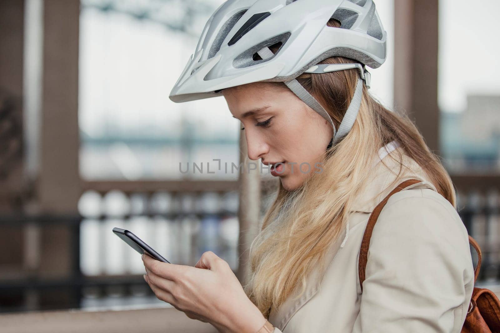 Side view of a businesswoman using her mobile phone on her morning cycle to work.