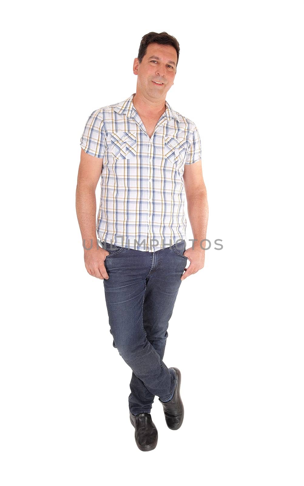 A tall handsome man standing in jeans and a checkered shirt with his.thumbs in his pocket, isolated for white background.