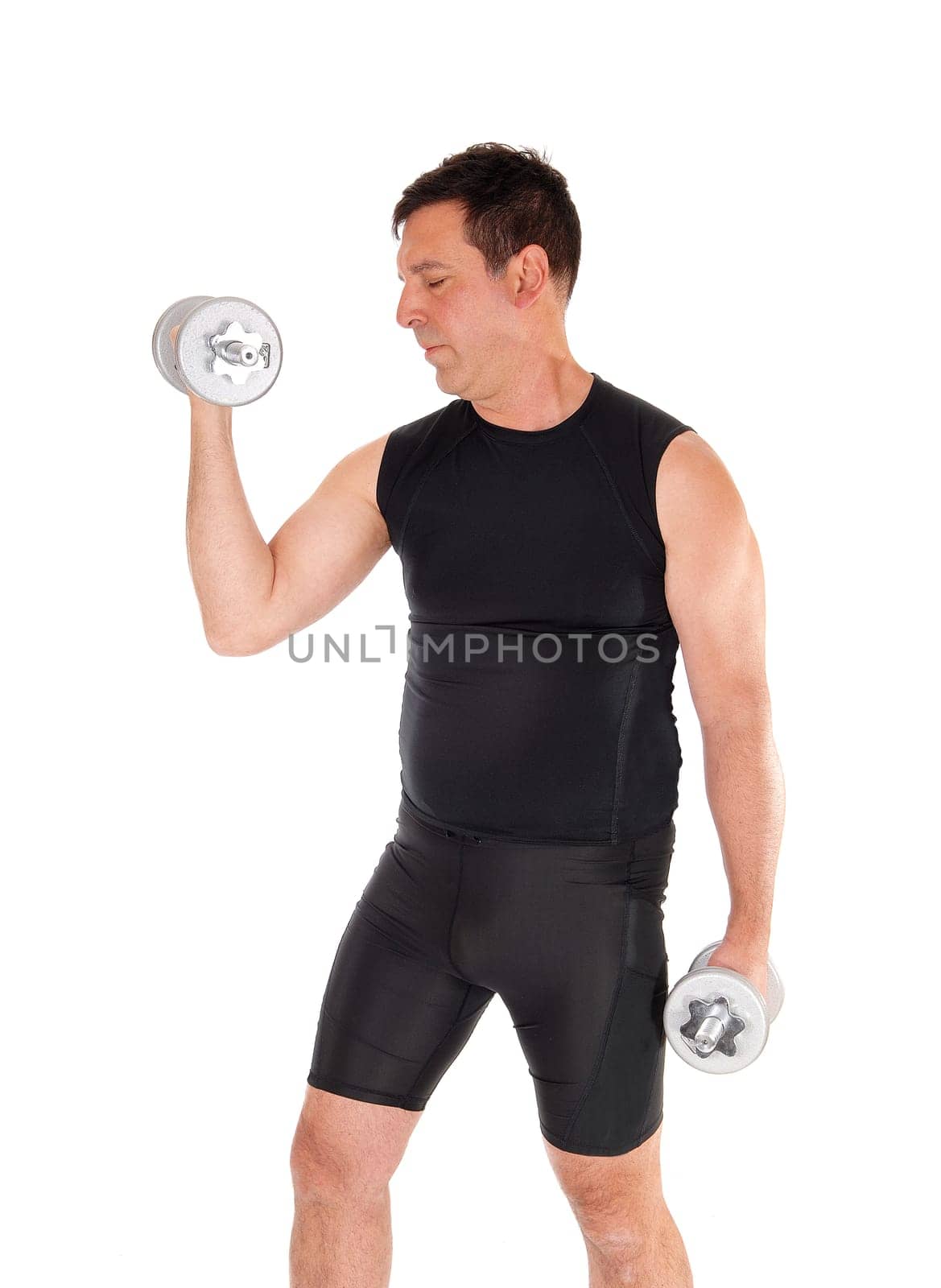 A man, standing in profile with his eyes closed and in a black.exercising outfit working the dumbbells, isolated over white.