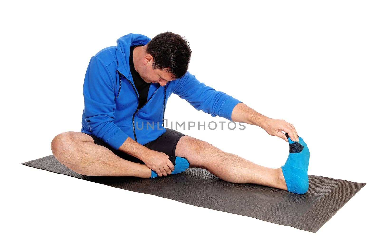 A middle age man in a blue hoody and shorts sitting on the floor.stretching his body on a mat, isolated for white background.