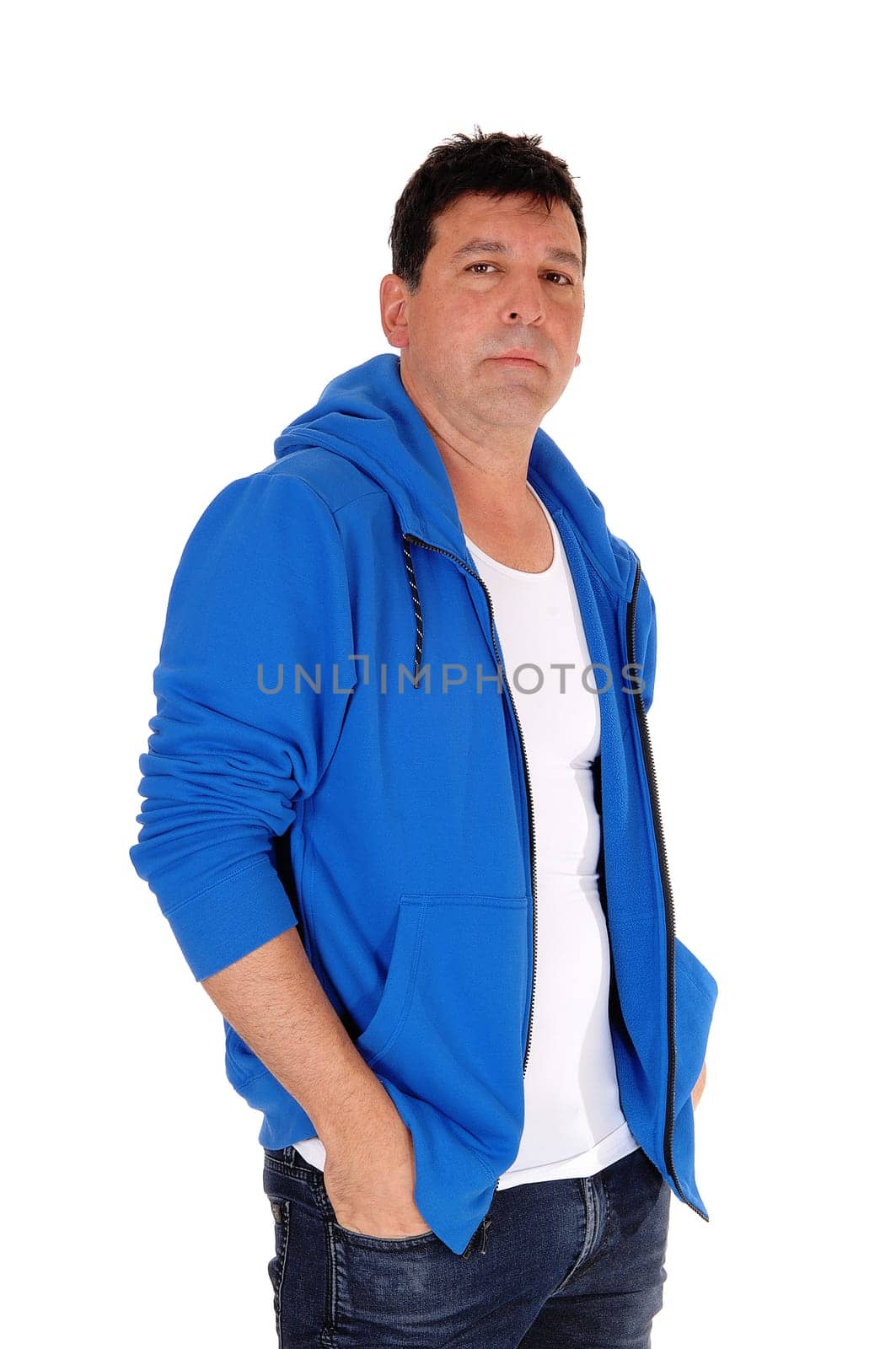 A tall handsome man standing in a blue hoody with his hands in his.pocket, isolated for white background.