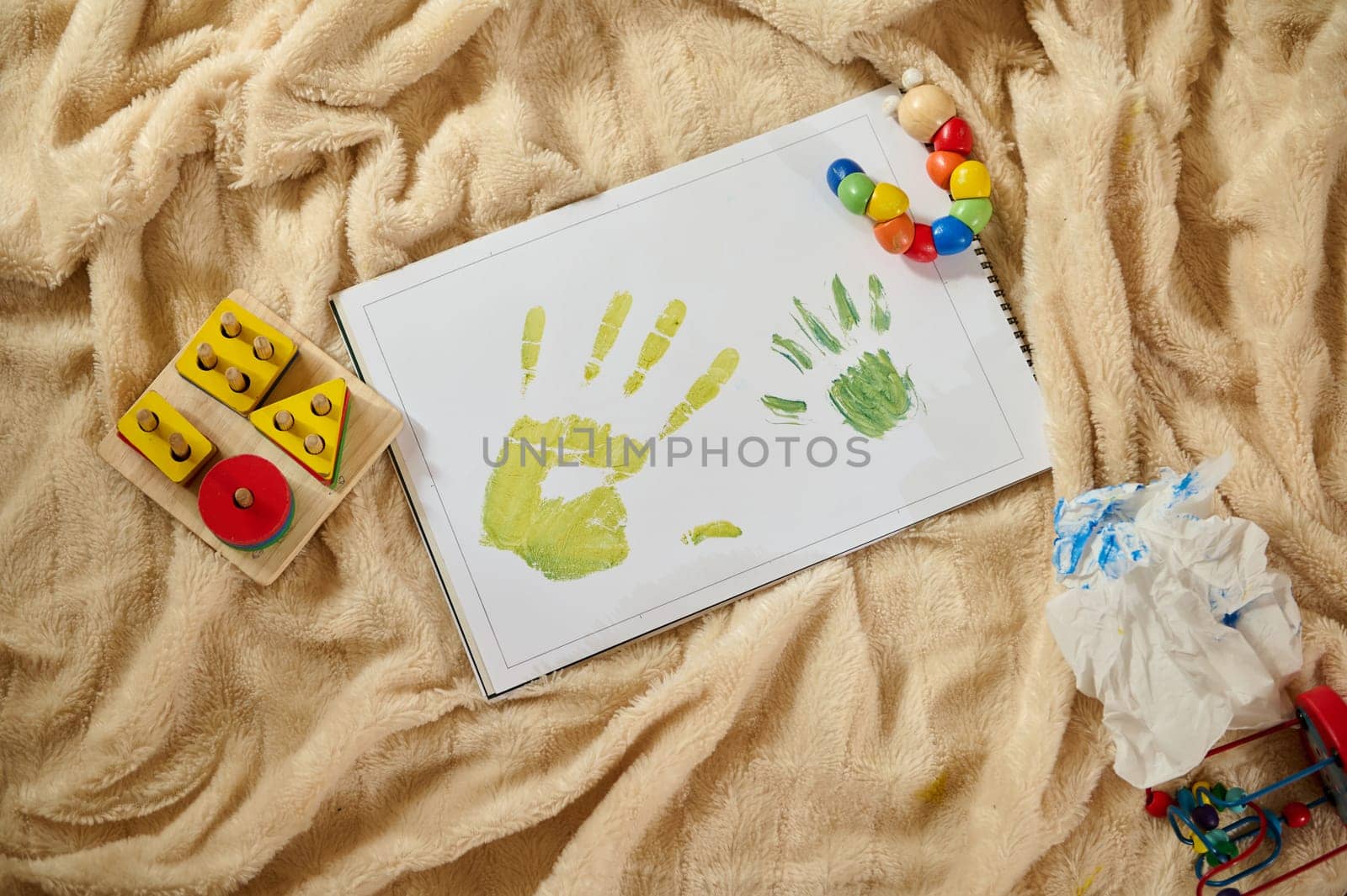 A vibrant depiction of children's handprint artwork, embodying creativity and family time on a soft surface, with colorful toys adding a playful atmosphere.