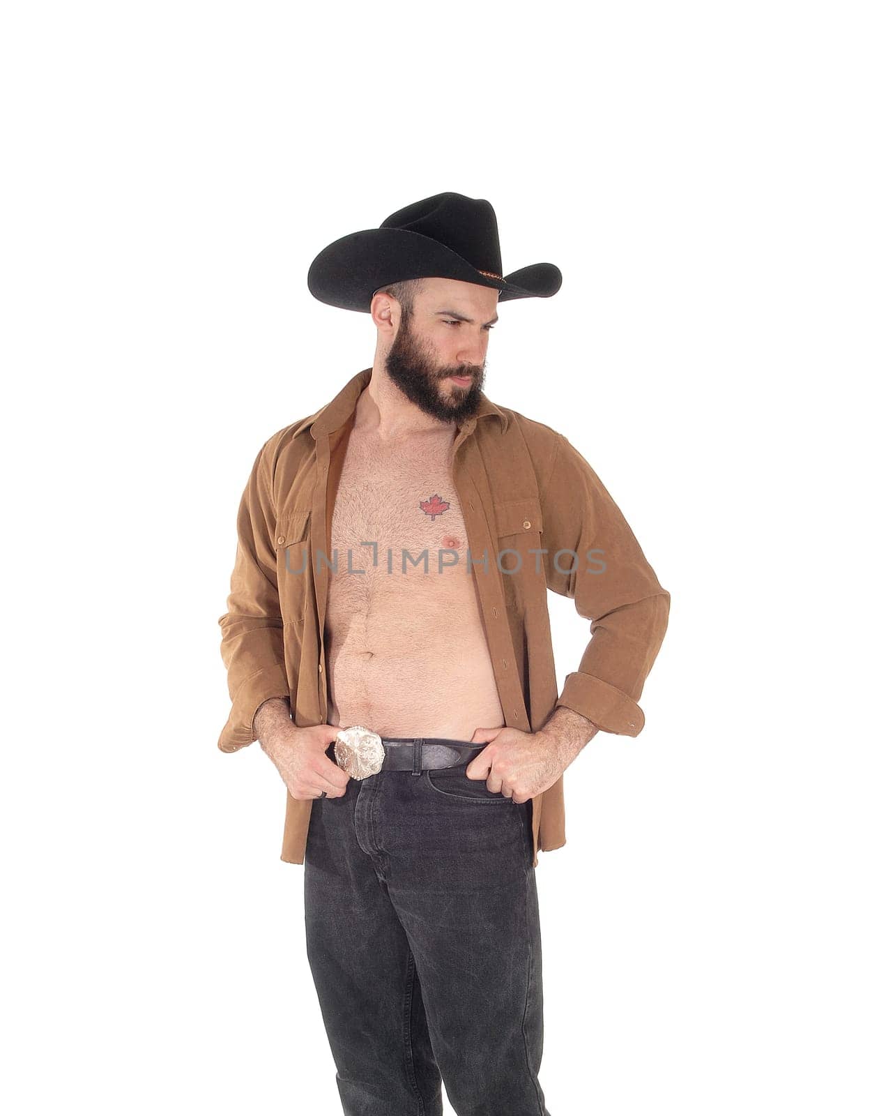 A close up image of a young man in a open brown shirt wearing a.cowboy hat and black jeans, isolated for white background.