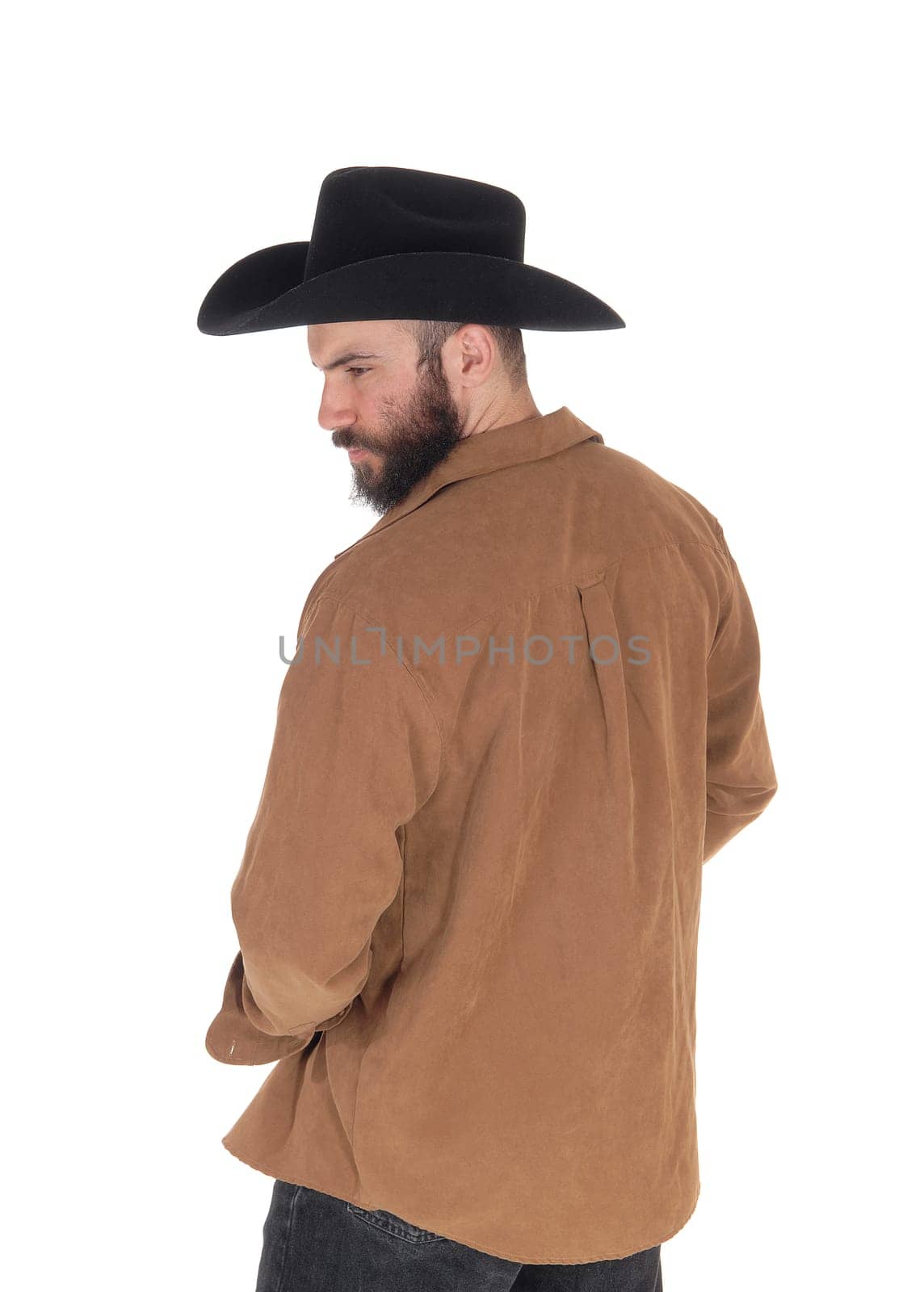 A man in his forties standing in a brown shirt and black cowboy hat.from the back, looking at the side, isolated for white background.