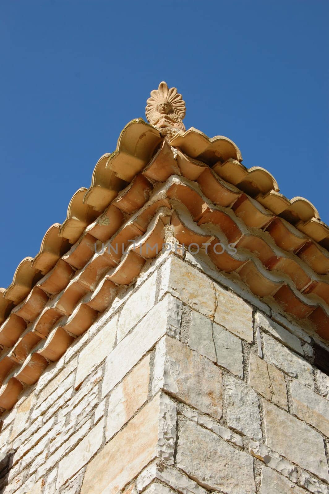 Ceramic antefix decorative pottery ornament on the roof of a house in Greece. Architectural detail.