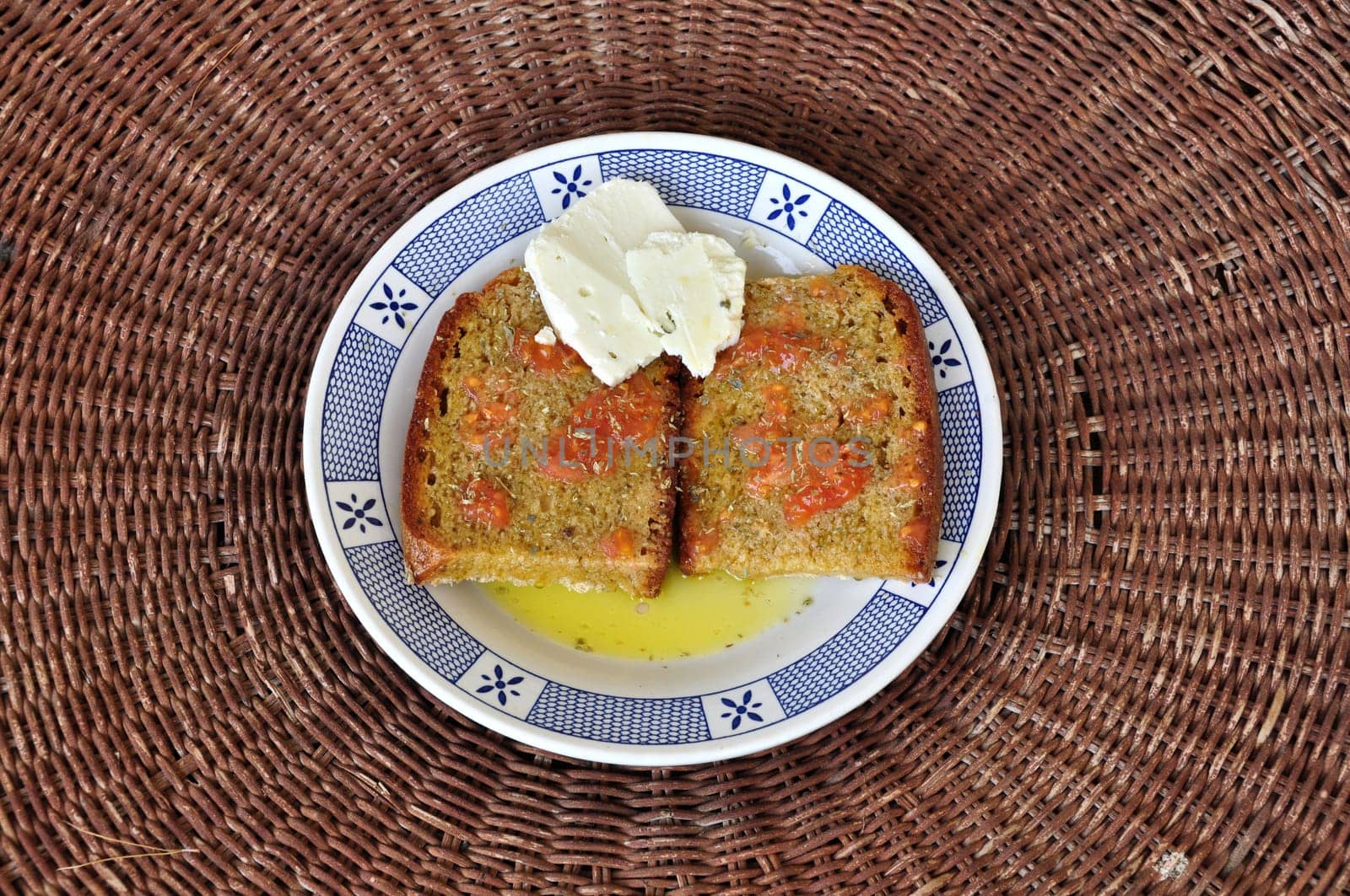 Dark bread with olive oil, tomato, dried oregano and cheese. Greek traditional appetizer food with products from the island of Zakynthos.